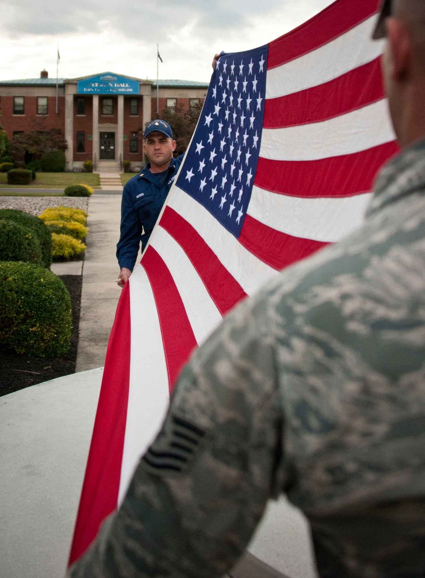 An honor guard formation representing all five services folds the flag during a retreat ceremony Sept. 26, 2013, on Sharpe Field at Joint Base McGuire-Dix-Lakehurst, N.J. (U.S. Air Force photo by Airman 1st Class Ryan Throneberry/Released)