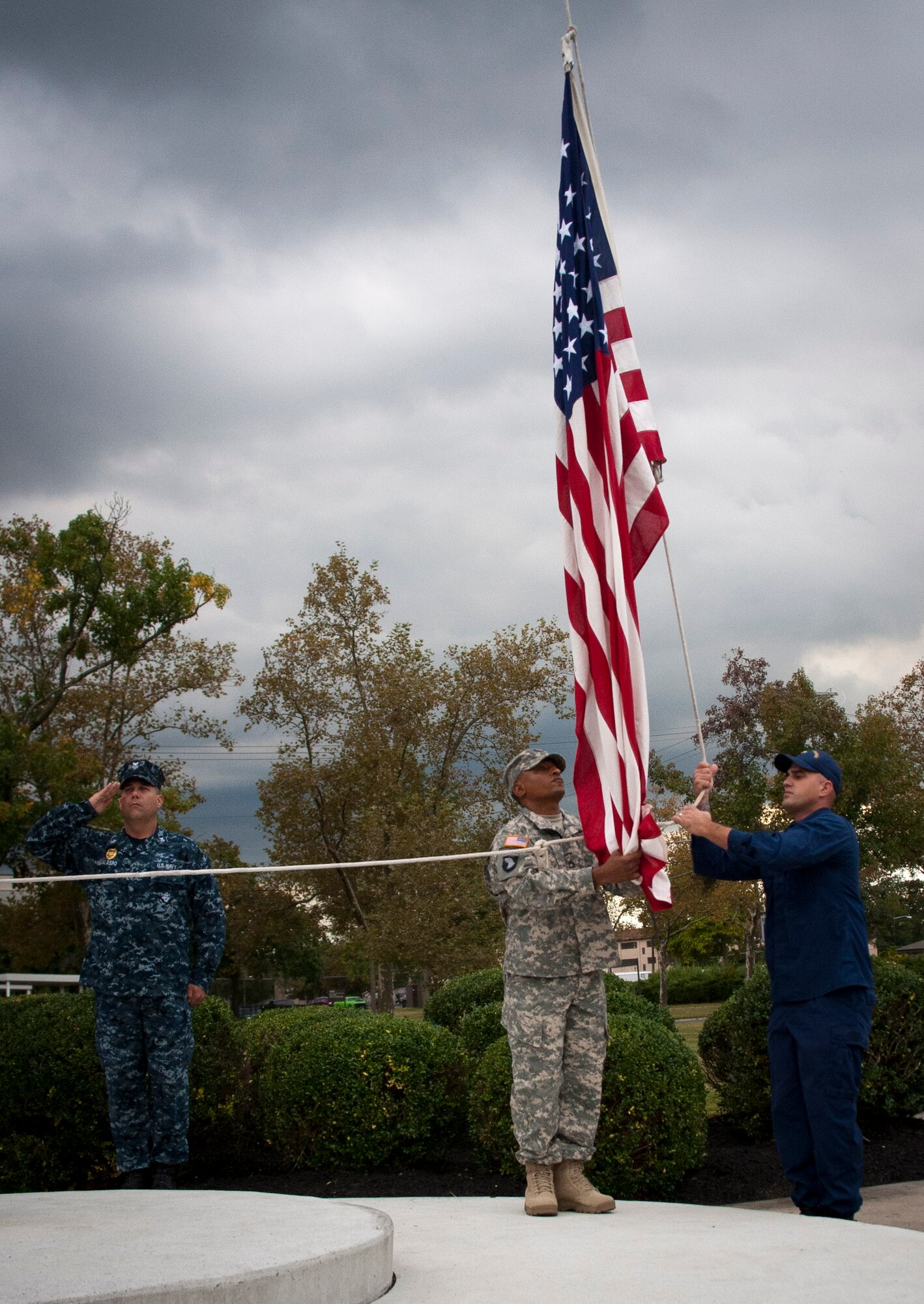 An honor guard formation representing all five services lower the flag during a retreat ceremony Sept. 26, 2013, on Sharpe Field at Joint Base McGuire-Dix-Lakehurst, N.J. (U.S. Air Force photo by Airman 1st Class Ryan Throneberry/Released)