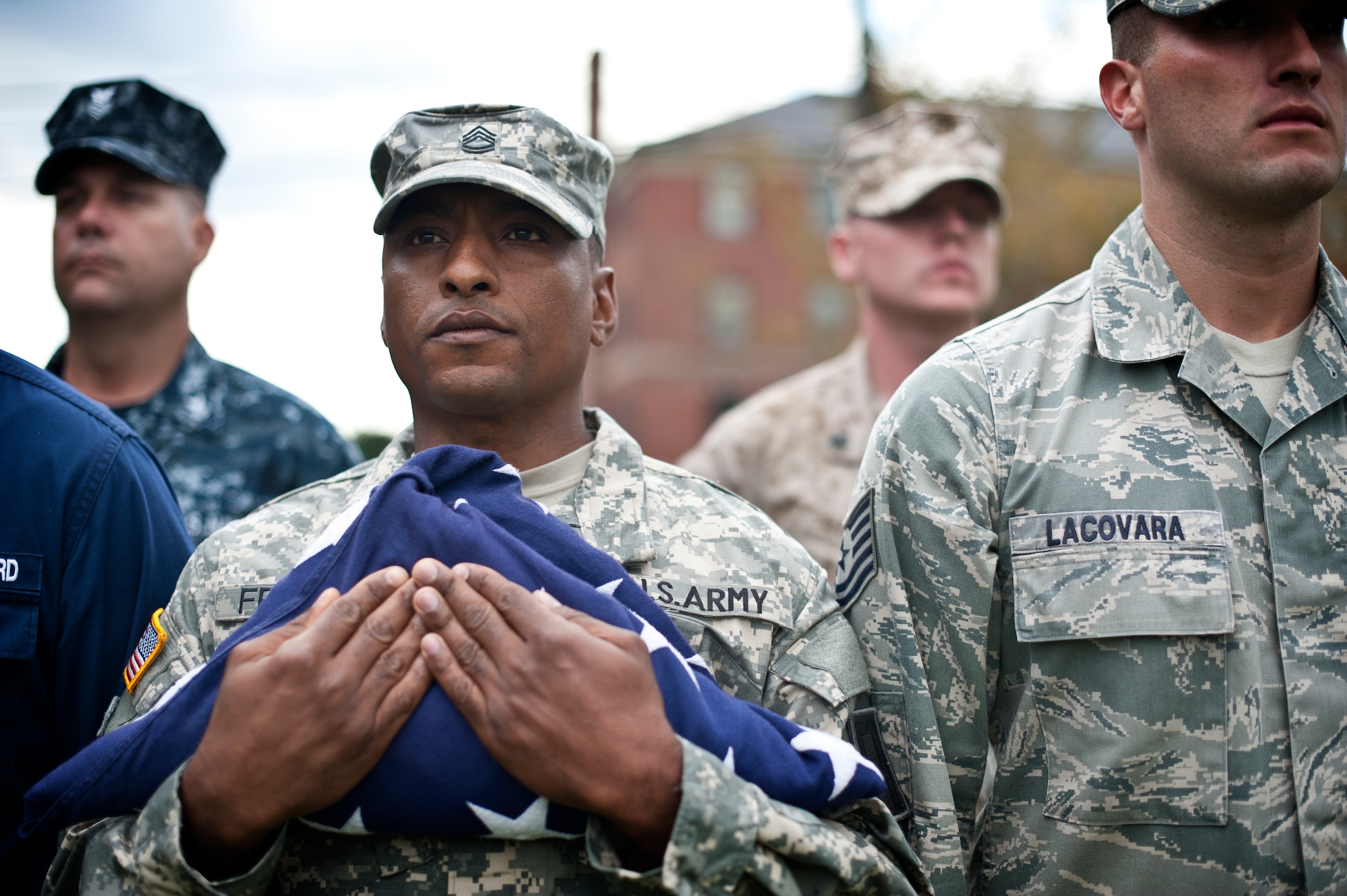 An honor guard formation representing all five services holds a folded American flag during a retreat ceremony Sept. 26, 2013, on Sharpe Field at Joint Base McGuire-Dix-Lakehurst, N.J. (U.S. Air Force photo by Staff Sgt. Katherine Tereyama/Released)
