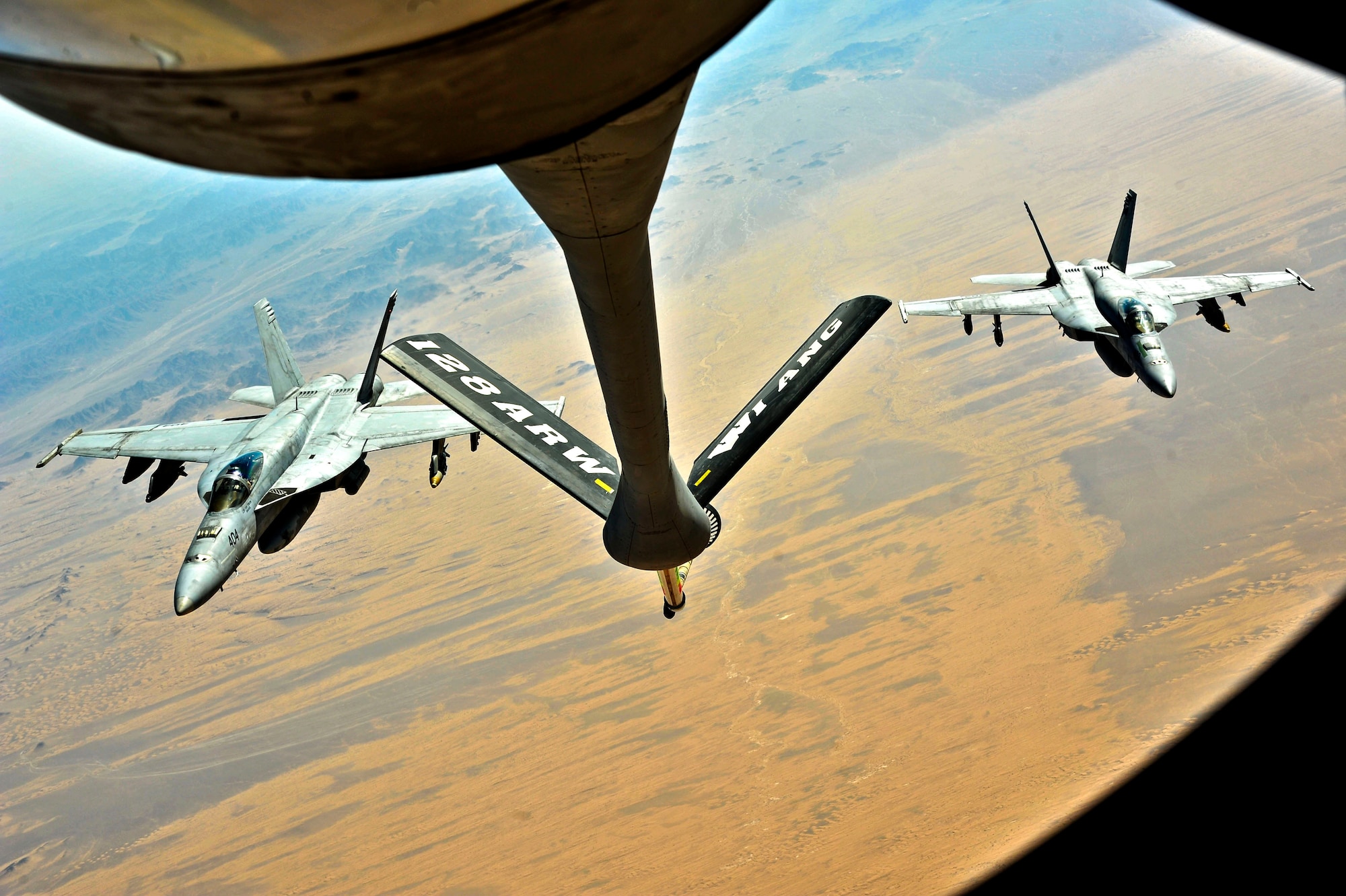 Two U.S. Navy F/A-18 Hornets maneuver behind a KC-135 Stratotanker for refueling in Southwest Asia, Oct. 1, 2013. The aircraft is assigned to the 340th Expeditionary Air Refueling Squadron deployed from the 128th Air Refueling Wing (Wisconsin Air National Guard), in Milwaukee.  (U.S. Air Force photo/Tech. Sgt. Joselito Aribuabo)