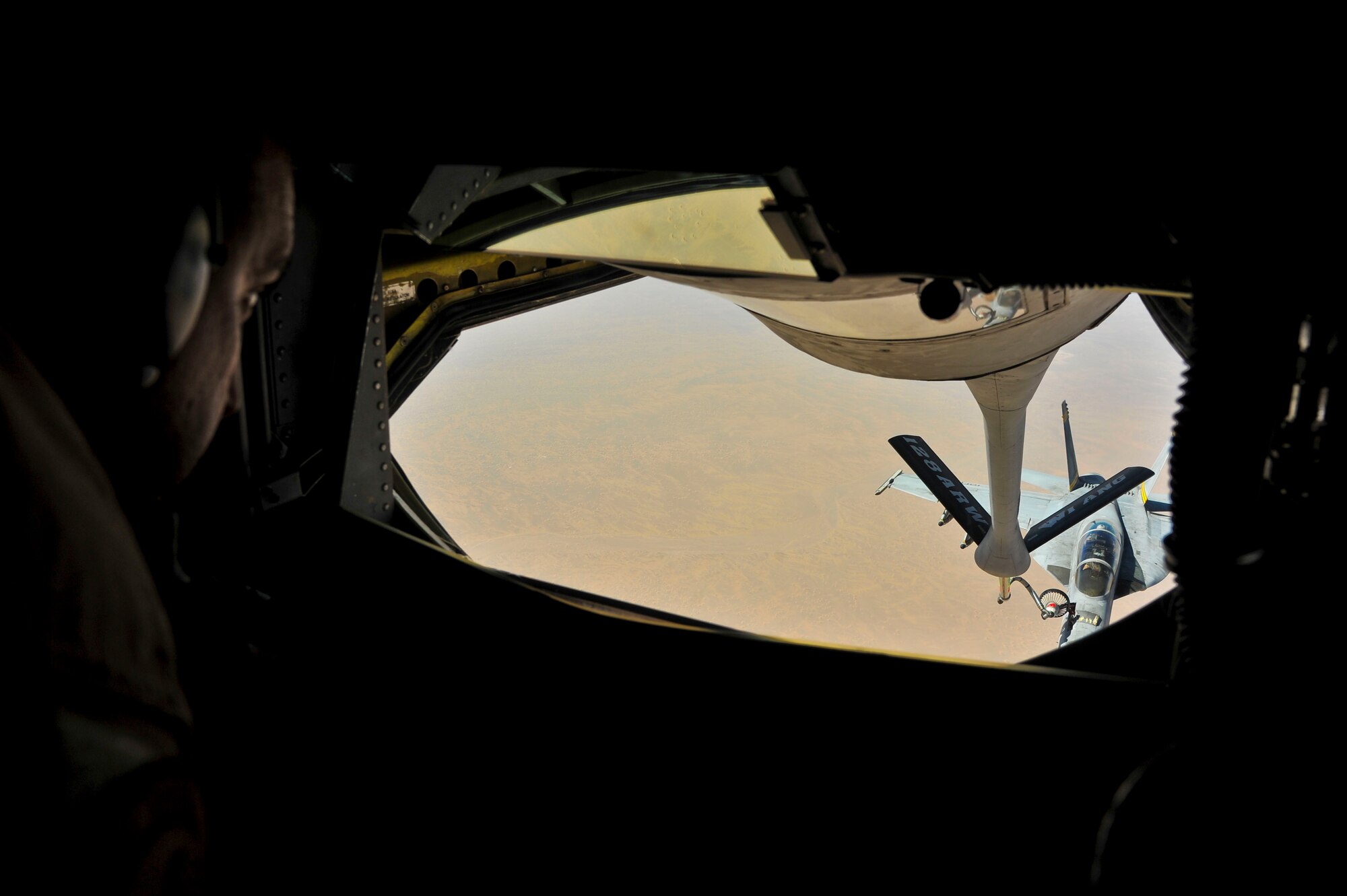Tech. Sgt. Jordan Jungwirth IV, operates the boom from a pod in the back of a KC-135 Stratotanker while refueling a U.S. Navy F/A-18 Hornet in Southwest Asia, Oct. 1, 2013.  Jungwirth is a 340th Expeditionary Air Refueling Squadron boom operator deployed from the 128th Air Refueling Wing (Wisconsin Air National Guard) in Milwaukee, and hails from Oshkosh, Wis. (U.S. Air Force photo/Tech. Sgt. Joselito Aribuabo)
