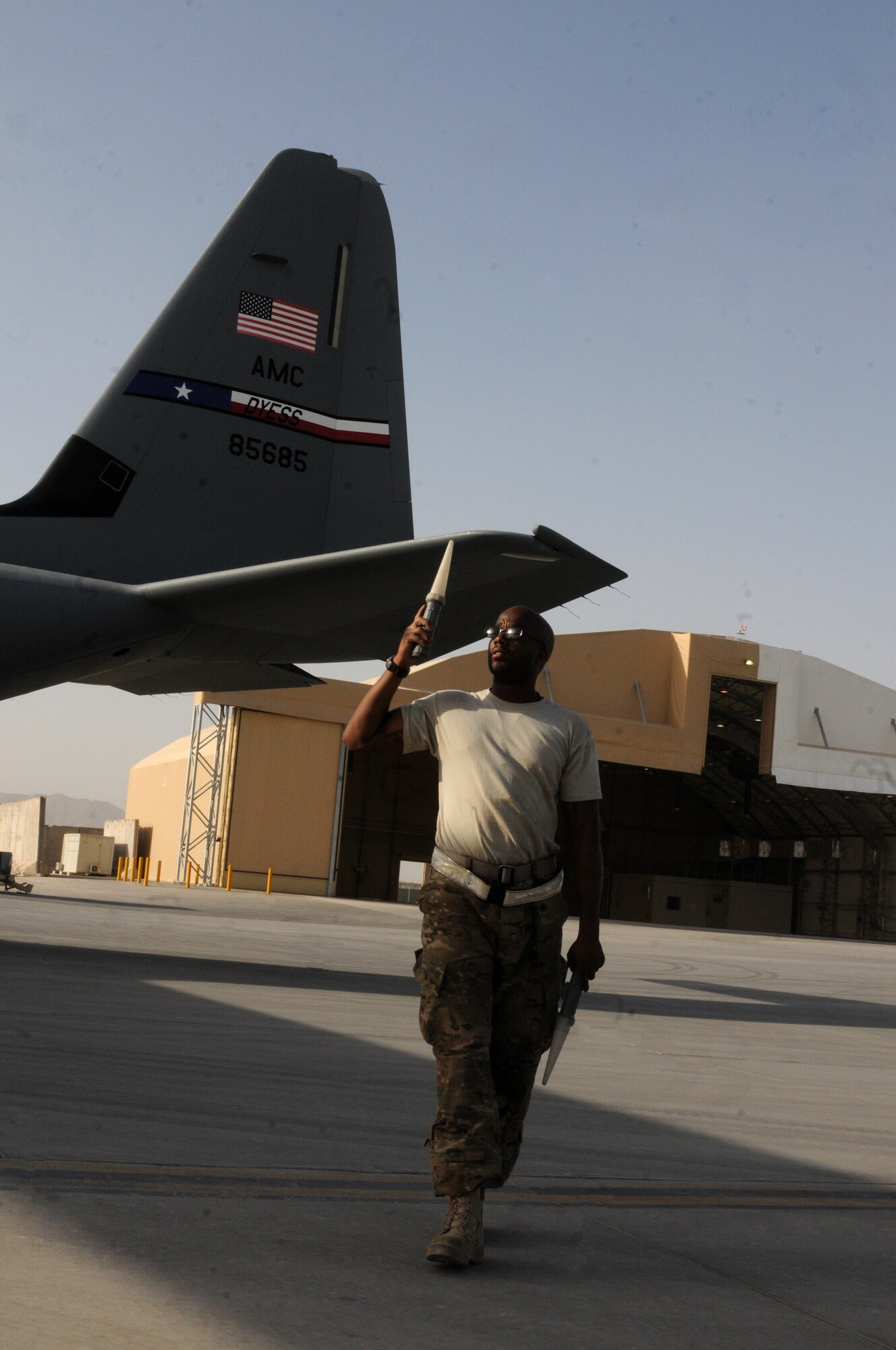 An Airman from the 451st Expeditionary Aircraft Maintenance Squadron marshals a C-130J Hercules into a hangar Sept. 28, 2013 at Kandahar Airfield, Afghanistan. The C-130 Hercules, tail no. 85685, was the first aircraft to use the C-130 hangar that was recently completed here. (U.S. Air Force photo by Senior Airman Jack Sanders)