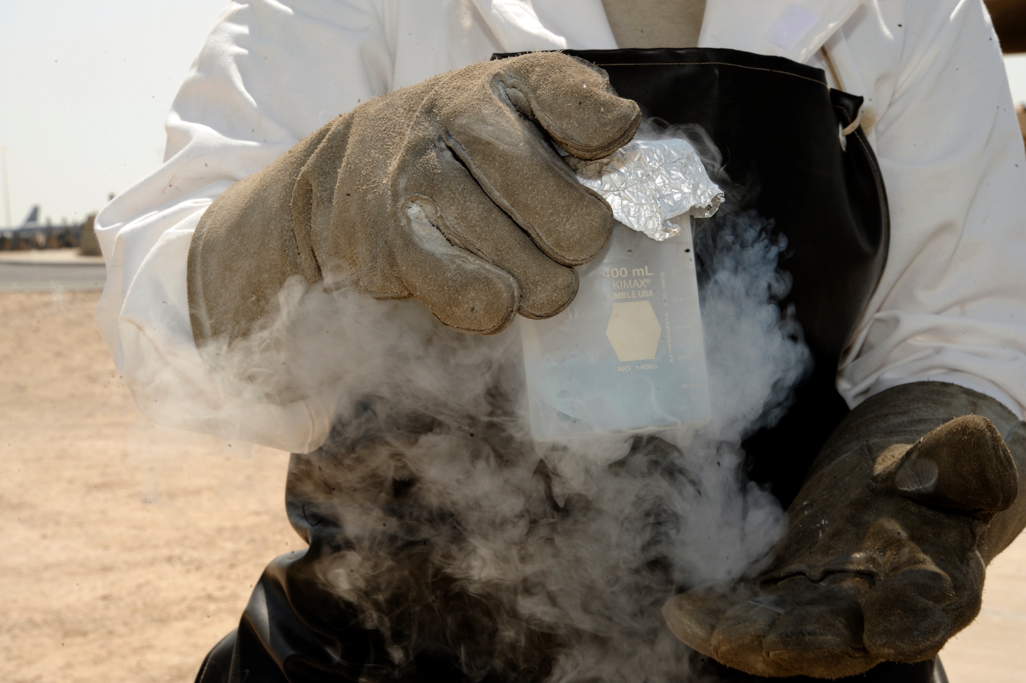 Staff Sgt. Sarah Sarten holds a sample from a freshly filled tank if liquid oxygen at the 379th Air Expeditionary Wing in Southwest Asia, Oct. 1, 2013. Once the sample is collected, cryogenics technicians must perform an odor test to ensure the liquid oxygen is good for use. Sarten is a 379th Expeditionary Logistics Readiness Squadron cryogenics supervisor deployed from Scott Air Force Base, Ill., and a Concord, N.C., native. (U.S. Air Force photo/Senior Airman Bahja J. Jones) 