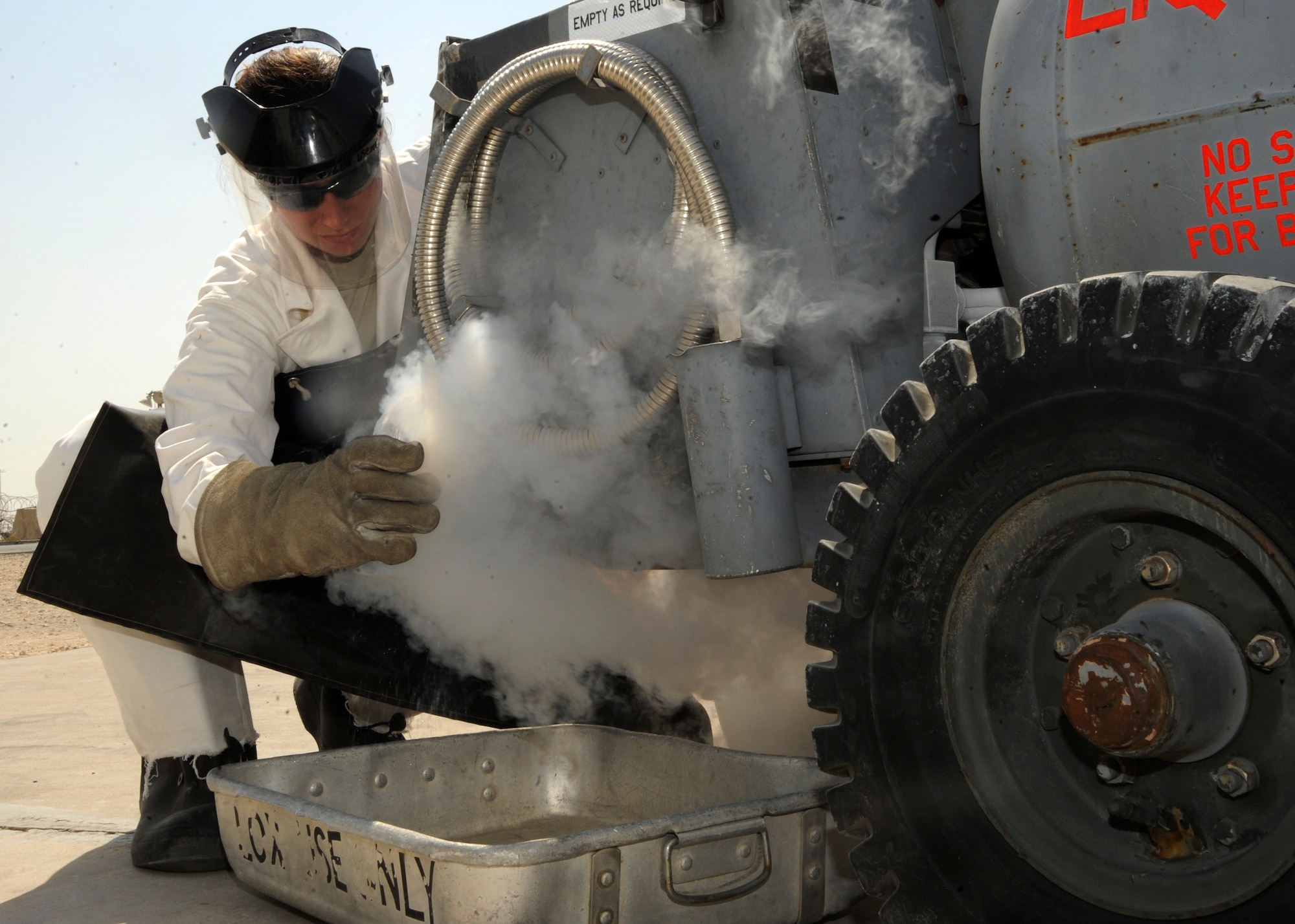 Staff Sgt. Sarah Sarten collects a sample from a freshly filled tank of liquid oxygen at the 379th Air Expeditionary Wing in Southwest Asia, Oct. 1, 2013. Every day, the cryogenics shop supplies an average of 150 gallons of liquid oxygen to aircraft at the 379th Air Expeditionary Wing here and ships an average of 12,000 gallons of liquid oxygen and about 800 gallons of liquid nitrogen each month to other bases in the region. Sarten is a 379th Expeditionary Logistics Readiness Squadron cryogenics supervisor deployed from Scott Air Force Base, Ill., and a Concord, N.C., native. (U.S. Air Force photo/Senior Airman Bahja J. Jones) 