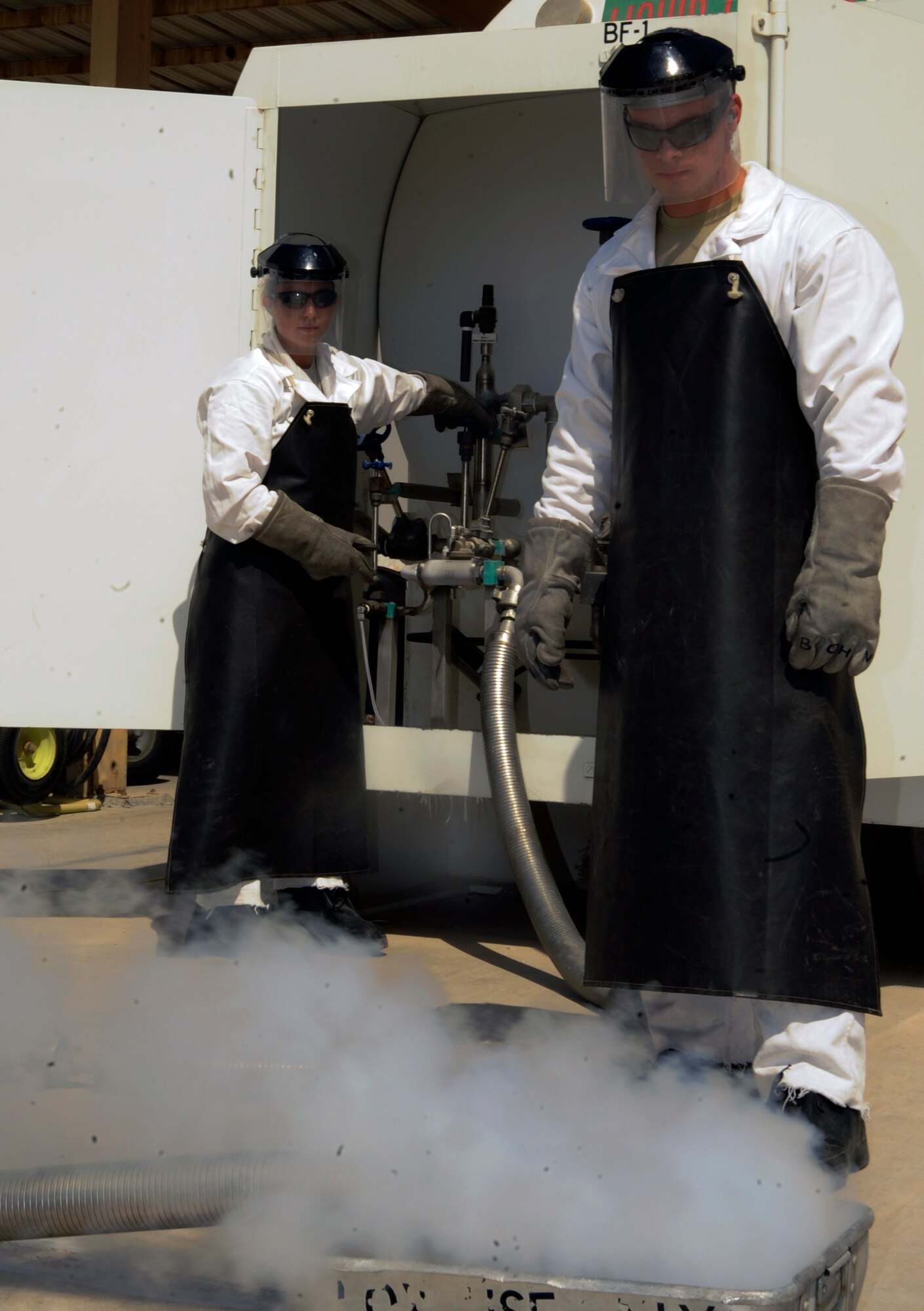 Staff Sgt. Sarah Sarten and Senior Airman John Justiniano purge a hose ensure only clean liquid oxygen is used to fill a cart at the 379th Air Expeditionary Wing in Southwest Asia, Oct. 1, 2013. Cryogenics technicians work suited from head to toe protecting them from serious injuries caused by the extreme temperatures of the substances they handle. Sarten is a 379th Expeditionary Logistics Readiness Squadron cryogenics supervisor deployed from Scott Air Force Base, Ill., and a Concord, N.C., native. Justiniano is a 379th ELRS cryogenics technician deployed from Joint Base Langley-Eustis, Va., and hails from Bronx, N.Y. (U.S. Air Force photo/Senior Airman Bahja J. Jones) 