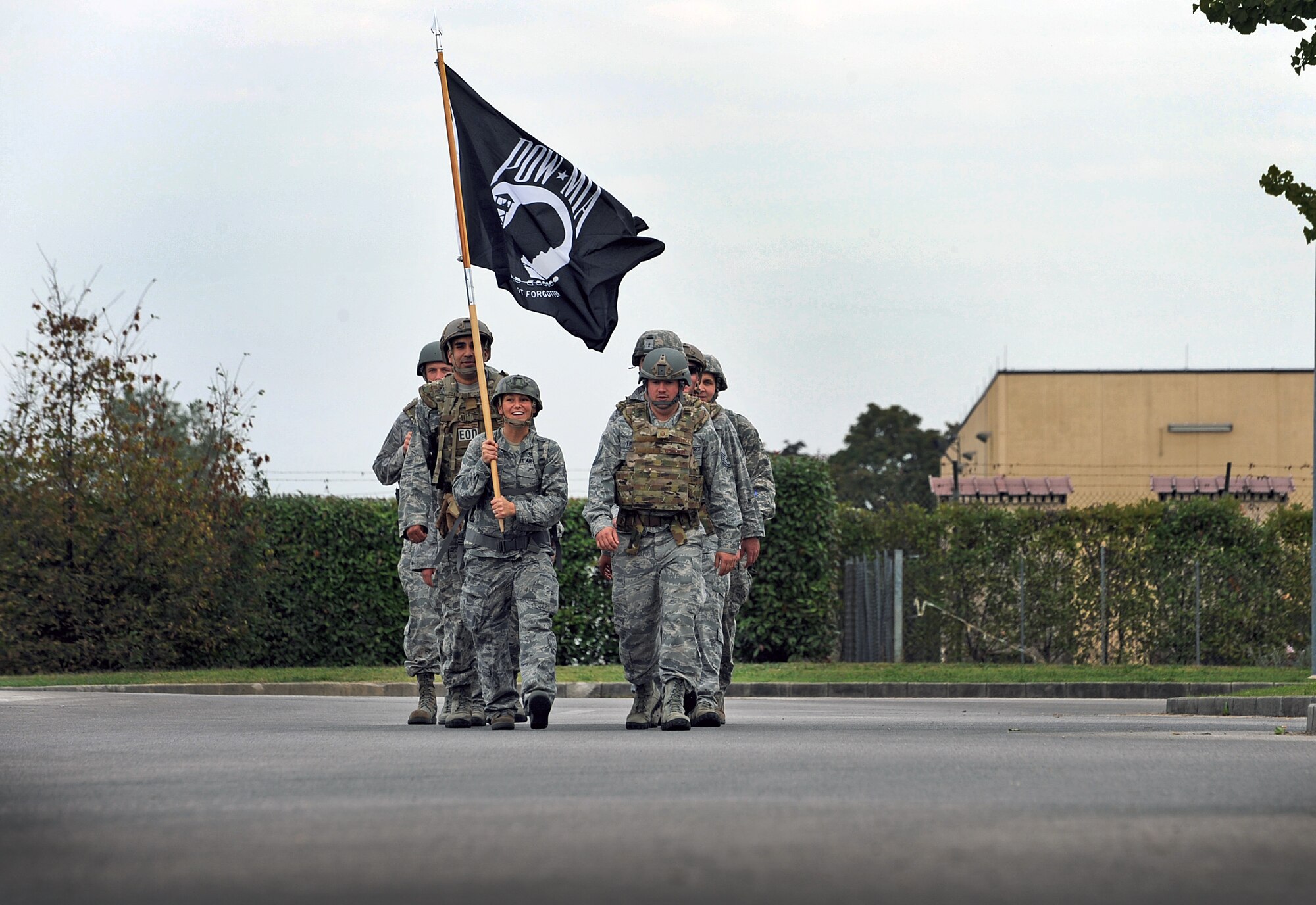 Members of the 31st Civil Engineer Squadron explosives ordinance disposal unit, march with the Prisoners of war/Missing in action flag, Oct. 3, 2013, at Aviano Air Base, Italy. Team Aviano marched the flag for 10 Kilometers around the base to recognize POW/MIA. (U.S. Air Force photo/Airman 1st Class Matthew Lotz)