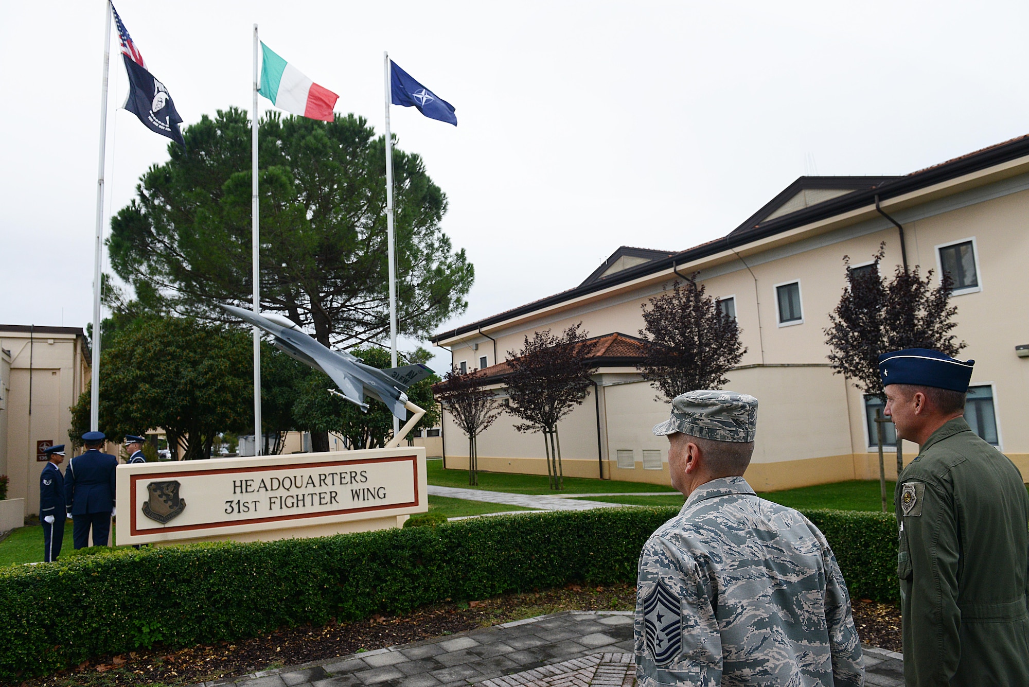 Chief Master Sgt. Mark Batzer, 31st Fighter Wing command chief, and Brig. Gen. Jon Norman, 31st FW commadner, stand at attention during a reveille ceremony for Prisoners of war/Missing in action memorial week, Sept. 30, 2013, at Aviano Air Base, Italy. Since World War 2, more than 80,000 service members are still unaccounted for from past American conflicts. (U.S. Air Force photo/Airman Ryan Conroy)