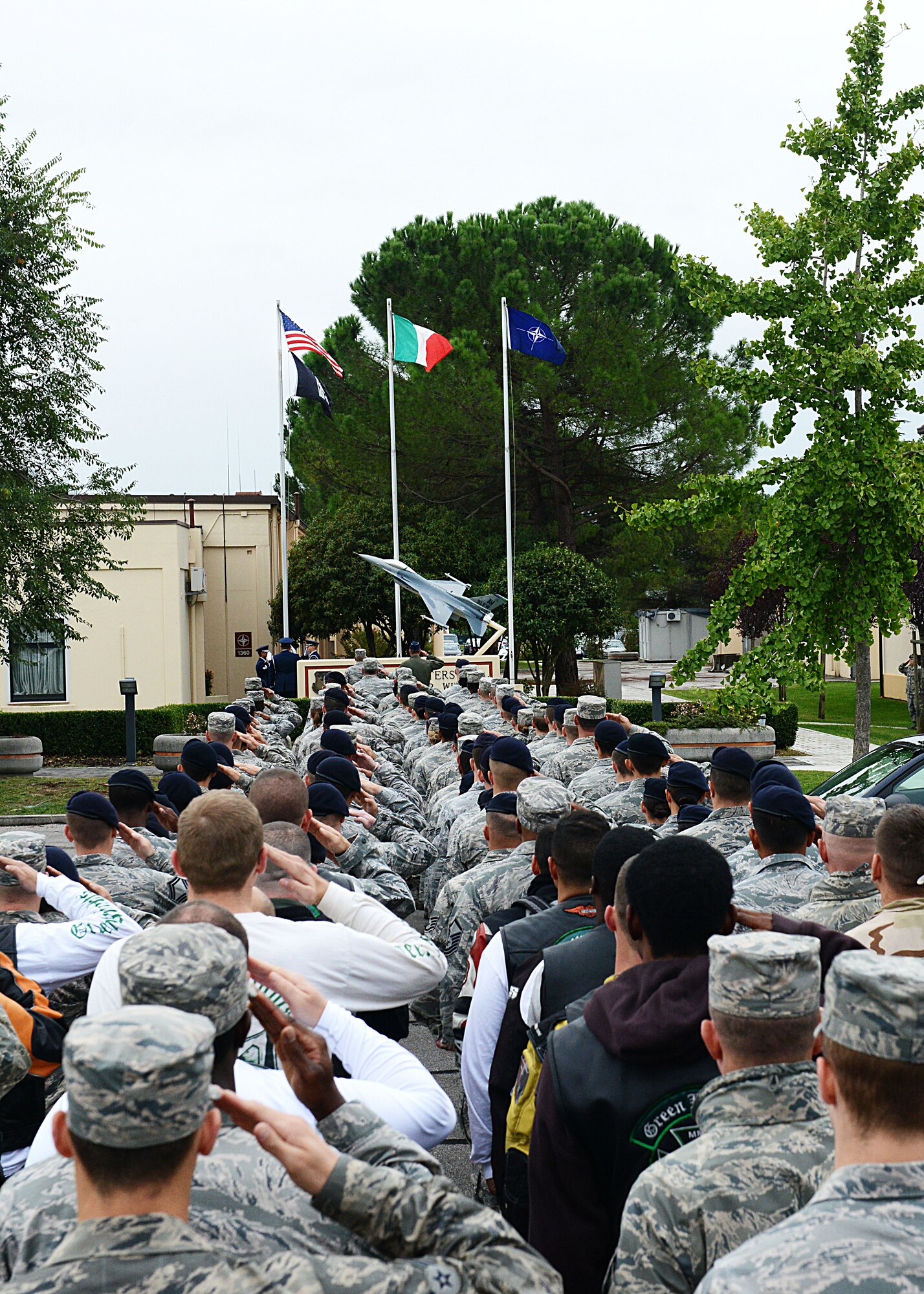 Team Aviano Airmen and civilians salute during a reveille ceremony for the start of Prisoners of war/Missing in action week, Sept. 30, 2013, at Aviano Air Base, Italy. Since World War 2, more than 80,000 service members are still unaccounted for from past American conflicts. (U.S. Air Force photo/Airman Ryan Conroy) 