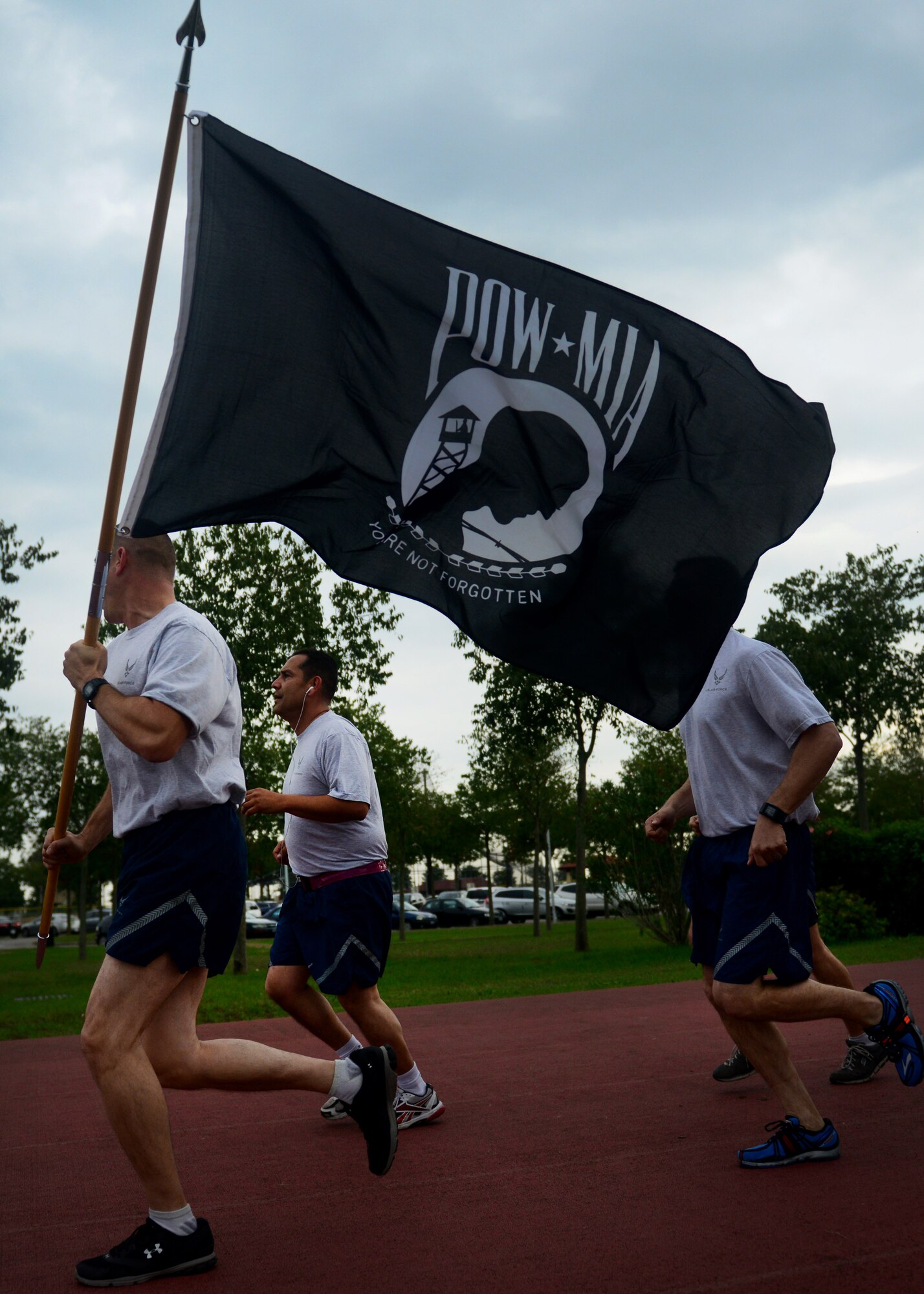 Pilots from the 510th Fighter Squadron run with the Prisoners of war/Missing in action memorial flag, Oct. 2, 2013, at Aviano Air Base, Italy. From Oct. 2-3, volunteers ran approximately 150 miles as part of a 24-hour vigil run.  (U.S. Air Force photo/Staff Sgt. Evelyn Chavez) 