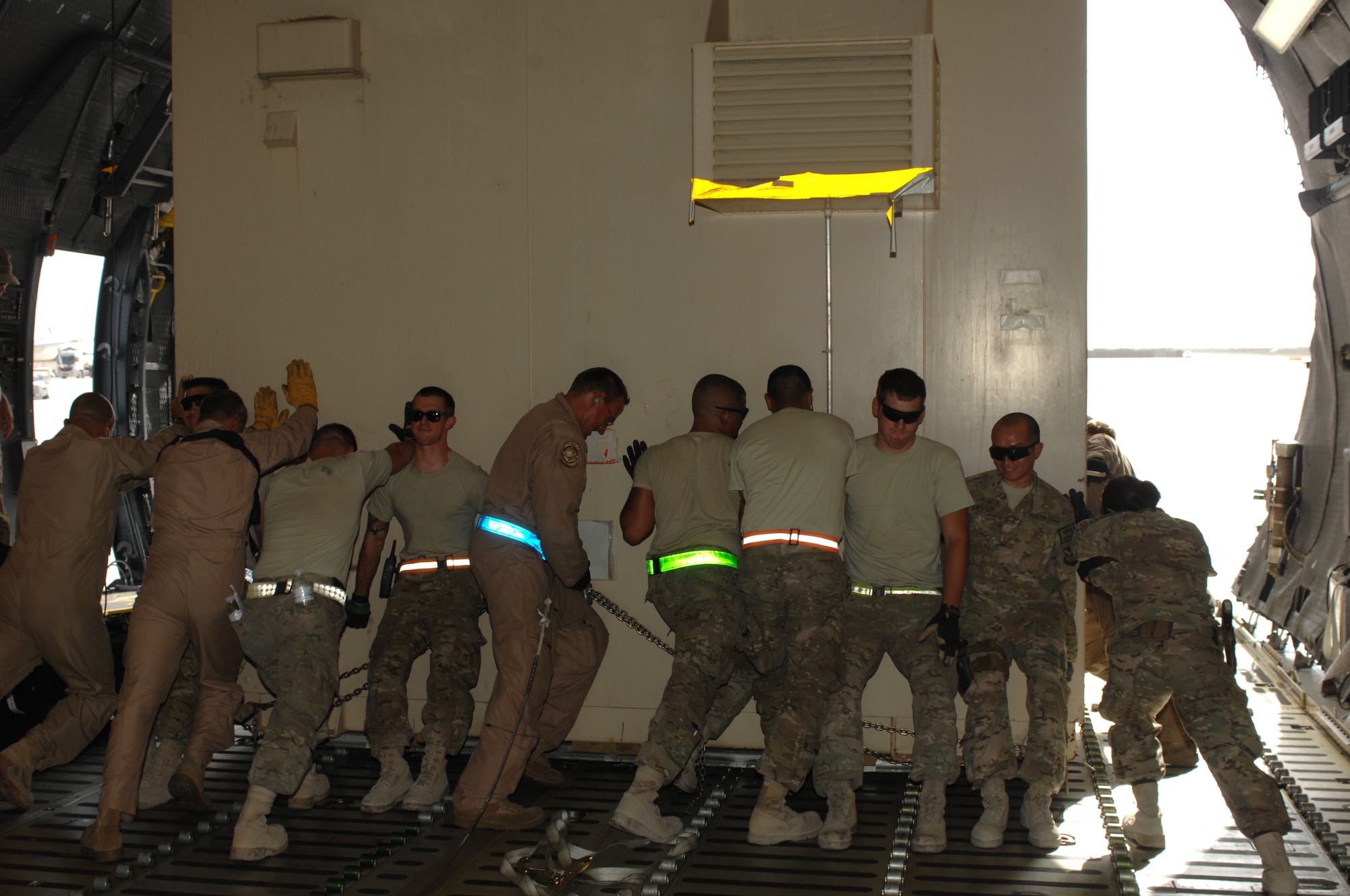 Airmen position to load a portable building onto a C-5M Super Galaxy at Kandahar Airfield, Afghanistan, Sept. 19, 2013. Airmen from the 451st Expeditionary Logistics Readiness Squadron Aerial Port Flight and 709th Airlift Squadron worked to load the building onto the C-5M as part of retrograde operations at Kandahar Airfield. (U.S. Air Force photo story/ Senior Airman Jack Sanders)