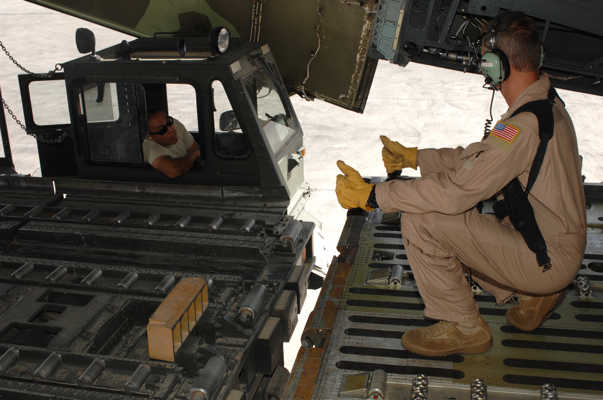 Master Sgt. Matthew Harr, 709th Airlift Squadron helps position an Airmen from the 451st Expeditionary Logistics Readiness Squadron Aerial Port Flight to unload supplies and equipment from a C-5M Super Galaxy at Kandahar Airfield, Afghanistan, Sept. 19, 2013. As NATO forces prepare to retrograde out of Afghanistan, the 451st ELRS Aerial Port Flight has ramped up operations to prevent bottlenecks in moving cargo out of Afghanistan. Harr is a from the Air Force Reserve Command’s 512th Airlift Wing at Dover Air Force Base, Del. (U.S. Air Force photo story/ Senior Airman Jack Sanders)