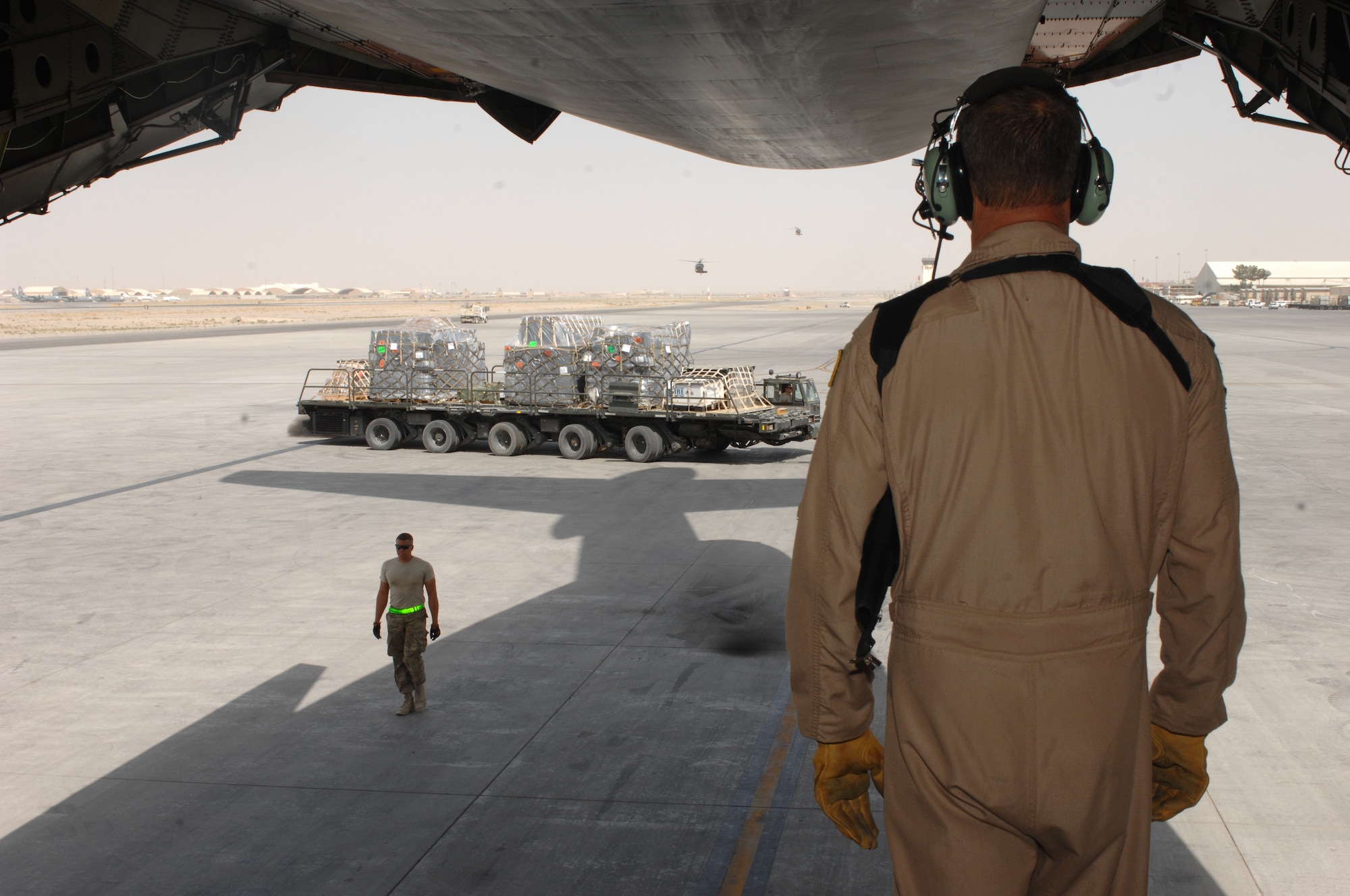 Master Sgt. Matthew Harr, 709th Airlift Squadron, watches as Airmen from the 451st Expeditionary Logistics Readiness Squadron Aerial Port Flight move supplies and equipment from a C-5M Super Galaxy at Kandahar Airfield, Afghanistan, Sept. 19, 2013. Airmen from the 451st ELRS Aerial Port flight load and unload cargo from military and civilian aircraft to supply U.S. and Coalition forces in Afghanistan. Harr is a from the Air Force Reserve Command’s 512th Airlift Wing at Dover Air Force Base, Del. (U.S. Air Force photo story/ Senior Airman Jack Sanders)