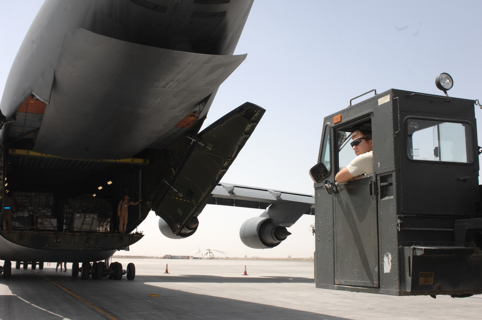 Airmen from the 451st Expeditionary Logistics Readiness Squadron Aerial Port Flight prepare to unload supplies and equipment from a C-5M Super Galaxy at Kandahar Airfield, Afghanistan, Sept. 19, 2013. As NATO forces prepare to retrograde out of Afghanistan, the 451st ELRS Aerial Port Flight has ramped up operations to prevent bottlenecks in moving cargo out of Afghanistan. (U.S. Air Force photo story/ Senior Airman Jack Sanders)