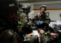 Staff Sgt. Jamilei Long, 8th Medical Operations Squadron, talks to her fellow medics while observing an injured patient during exercise Beverly Midnight 13-4 at Kunsan Air Base, Republic of Korea, Oct. 3, 2013. Exercises ensure the Wolf Pack medical staff is always prepared to respond in any situation. (U.S. Air Force photo by Staff Sgt. Jessica Haas/Released)