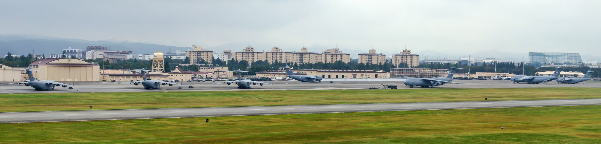 C-17A Globemaster's and C-5 Galaxy's park at Yokota Air Base, Japan, Oct. 4, 2013. Eighteen aircraft from Kadena Air Base and Marine Corps Air Station Futenma diverted to Yokota due to the inbound typhoon. (U.S. Air Force photo illustration by Osakabe Yasuo/Released) 