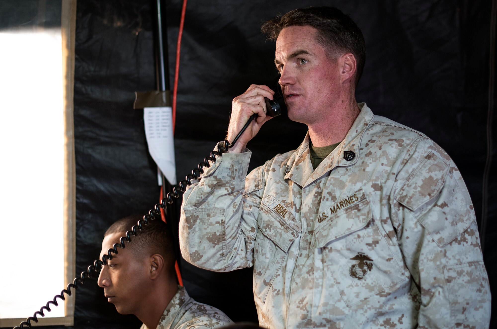 U.S. Marine Staff Sgt. Dustin Reel, 1st Air Naval Gunfire Liaison Company joint terminal attack controller and team chief, radios confirmation of enemy presence and calls for close-air support during exercise Mountain Roundup 2013 at Mountain Home Air Force Base, Idaho, Oct. 2, 2013. Aside from communicating with aviators, the ANGLICO teams can integrate both ground and naval surface fires to support the ground commander's scheme of maneuver. (U.S. Air Force photo by Master Sgt. Kevin Wallace/RELEASED)