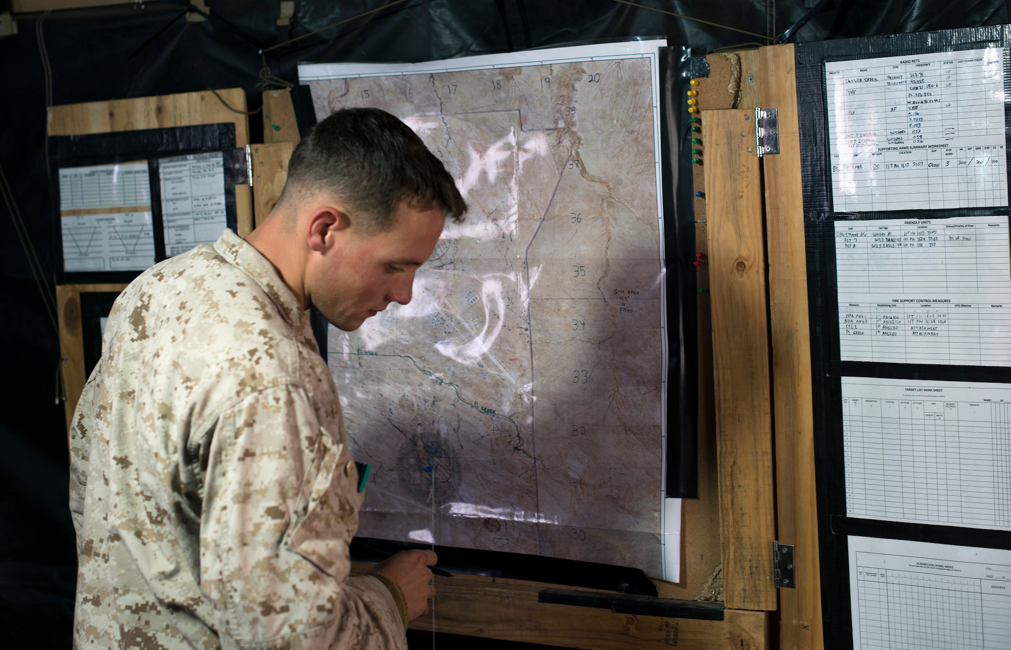 U.S. Marine Lance Cpl. Nicholas Thompson, 1st Air Naval Gunfire Liaison Company forward observer, plots a close-air support mission during exercise Mountain Roundup 2013 at Mountain Home Air Force Base, Idaho, Oct. 2, 2013. Aside from communicating with aviators, the ANGLICO teams can integrate both ground and naval surface fires to support the ground commander's scheme of maneuver. (U.S. Air Force photo by Master Sgt. Kevin Wallace/RELEASED)