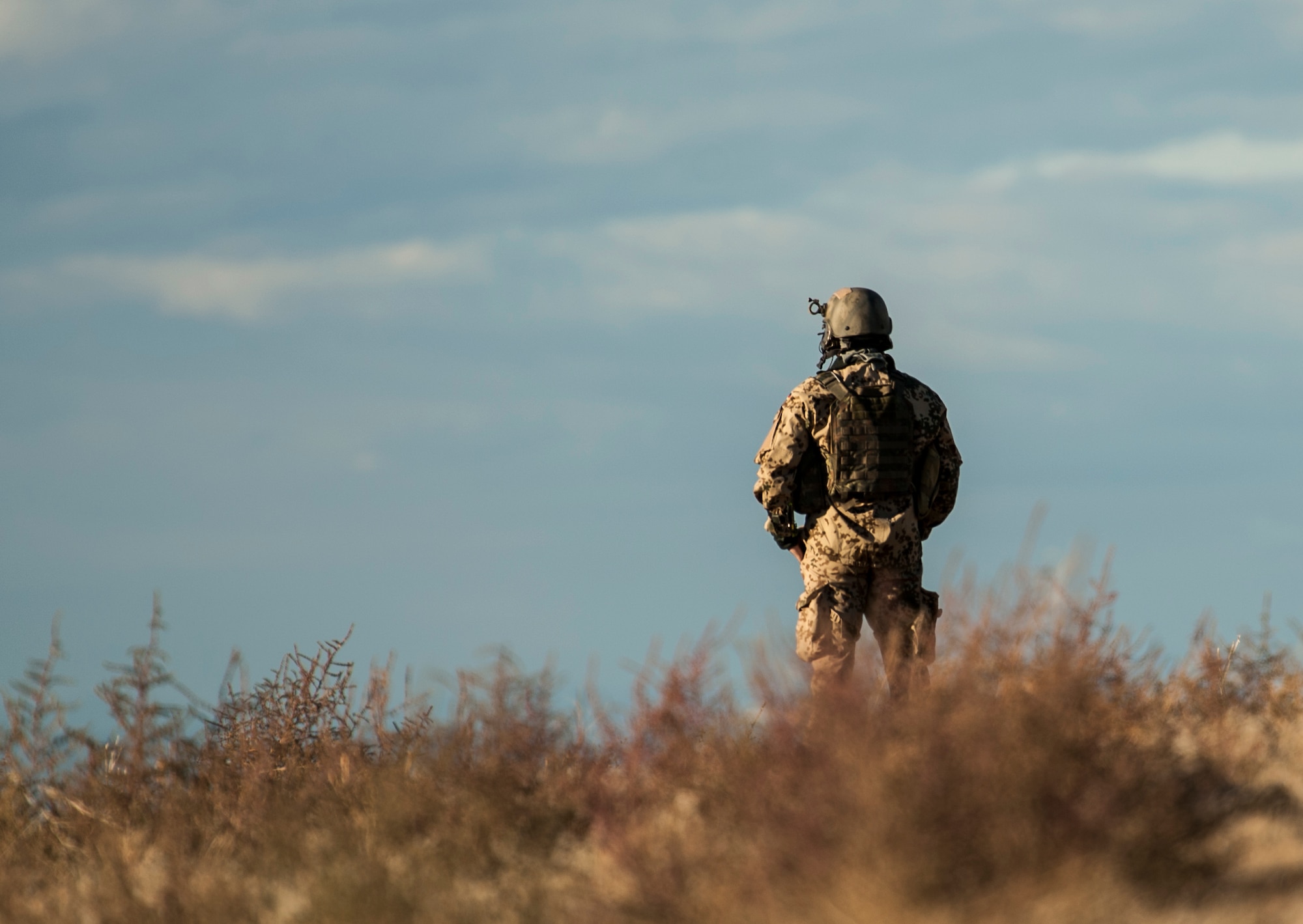A German Army joint terminal attack controller looks over a valley as he prepares to relay close-air support coordinates to a fellow JTAC during exercise Mountain Roundup 2013 at Mountain Home Air Force Base, Idaho, Oct. 2, 2013. "Everybody brings different capabilities to the fight and speaks different languages, so the challenge at Mountain Roundup is to determine who the best person is to task with various jobs and then execute professionally," said German Air Force Maj. Marcel Schlereth, exercise phase manager. (U.S. Air Force photo by Master Sgt. Kevin Wallace/RELEASED)