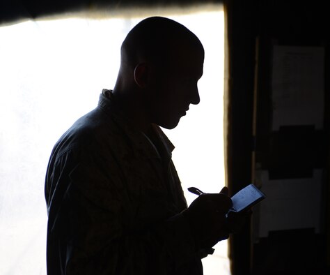 United States Marine Lance Cpl. Nicholas Thompson, 1st Air Naval Gunfire Liaison Company Supporting Arms Liaison Team radio operator, writes down coordinates Oct. 2, 2013, at the Saylor Creek Range complex near Mountain Home Air Force Base, Idaho. Seventeen Marines with the 1st ANGLICO SALT began conducting joint tactical air control party maneuvers at dawn. (U.S. Air Force photo by Senior Airman Benjamin Sutton/RELEASED)