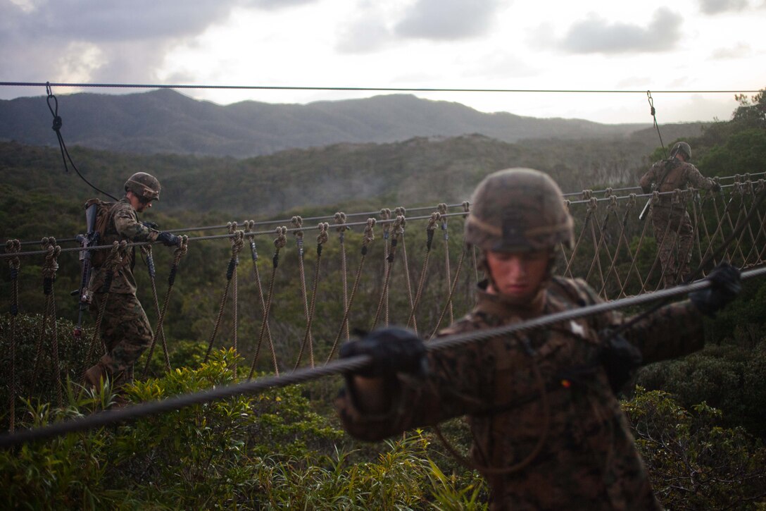 Marines with Company G., Battalion Landing Team 2nd Battalion, 4th Marines, 31st Marine Expeditionary Unit, cross a supported rope bridge (background) and simple rope bridge (foreground) during the culminating event of the Jungle Warfare Training Center’s jungle operations course here, Sept. 30. The Marines underwent a week of instruction in jungle warfare and survival skills. The culminating event tested the Marines in a jungle obstacle course spanning three miles through the Okinawan jungle. The 31st MEU is the only continuously forward-deployed MEU and is the Marine Corps’ force in readiness in the Asia-Pacific region. 