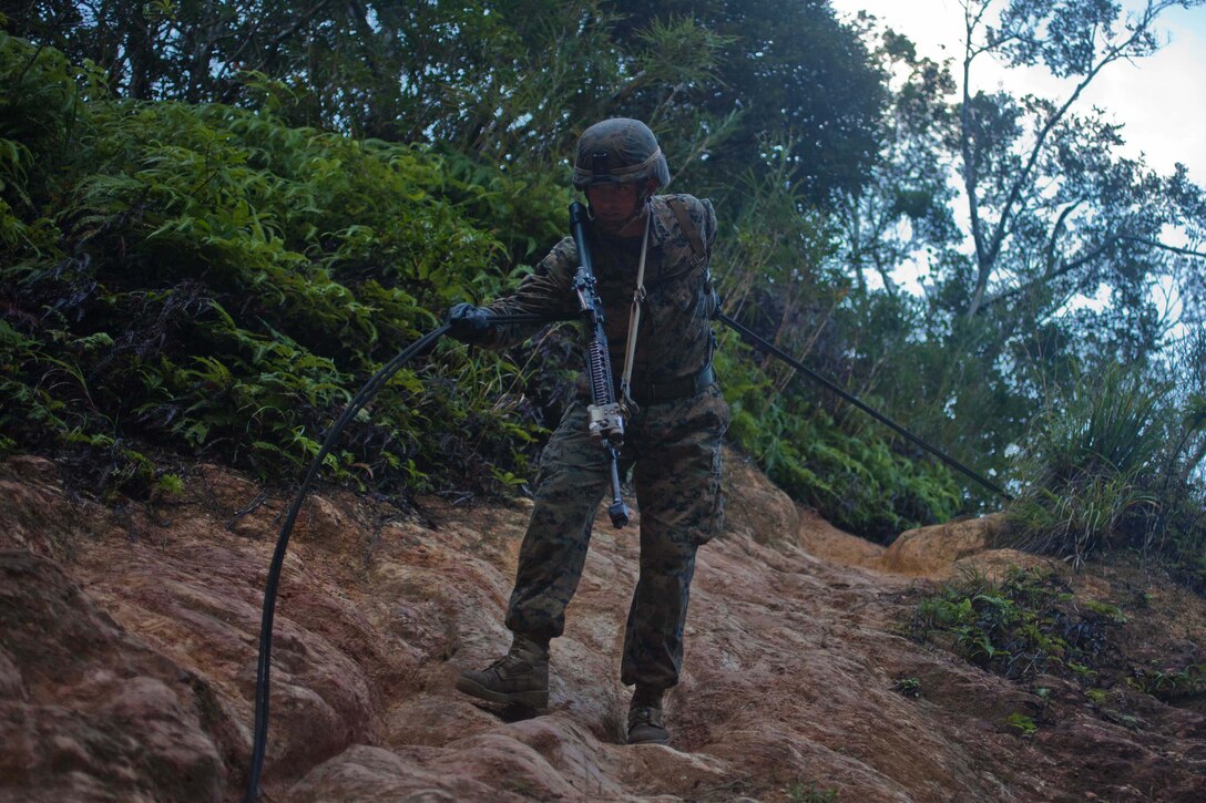 A Marine with Company G., Battalion Landing Team 2nd Battalion, 4th Marines, 31st Marine Expeditionary Unit, rappels down a cliff face during the culminating event of the Jungle Warfare Training Center’s jungle operations course here, Sept. 30. The Marines underwent a week of instruction in jungle warfare and survival skills. The culminating event tested the Marines in a jungle obstacle course spanning three miles through the Okinawan jungle. The 31st MEU is the only continuously forward-deployed MEU and is the Marine Corps’ force in readiness in the Asia-Pacific region.  