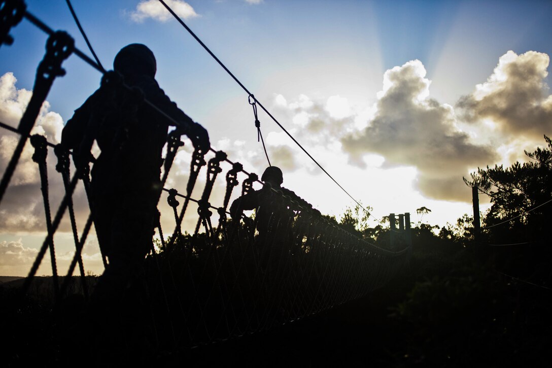 Marines with Company G., Battalion Landing Team 2nd Battalion, 4th Marines, 31st Marine Expeditionary Unit, cross a supported rope bridge as day breaks during the culminating event of the Jungle Warfare Training Center’s jungle operations course here, Sept. 30. The Marines underwent a week of instruction in jungle warfare and survival skills. The culminating event tested the Marines in a jungle obstacle course spanning three miles through the Okinawan jungle. The 31st MEU is the only continuously forward-deployed MEU and is the Marine Corps’ force in readiness in the Asia-Pacific region.