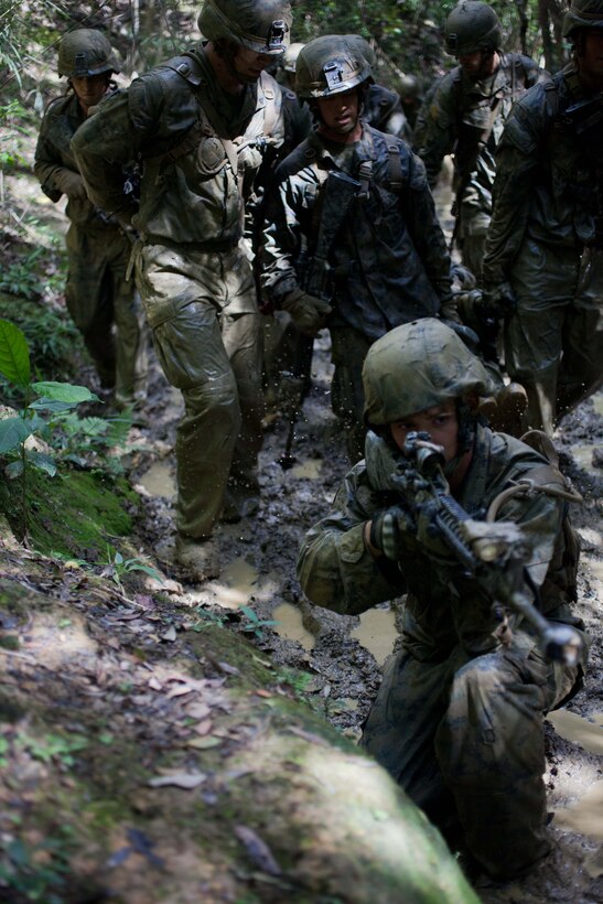 A Marine with Company G., Battalion Landing Team 2nd Battalion, 4th Marines, 31st Marine Expeditionary Unit, provides forward security as members of his squad carry a simulated casualty on an improvised stretcher during the culminating event of the Jungle Warfare Training Center’s jungle operations course here, Sept. 30. The Marines underwent a week of instruction in jungle warfare and survival skills. The culminating event tested the Marines in a jungle obstacle course spanning three miles through the Okinawan jungle. The 31st MEU is the only continuously forward-deployed MEU and is the Marine Corps’ force in readiness in the Asia-Pacific region.  