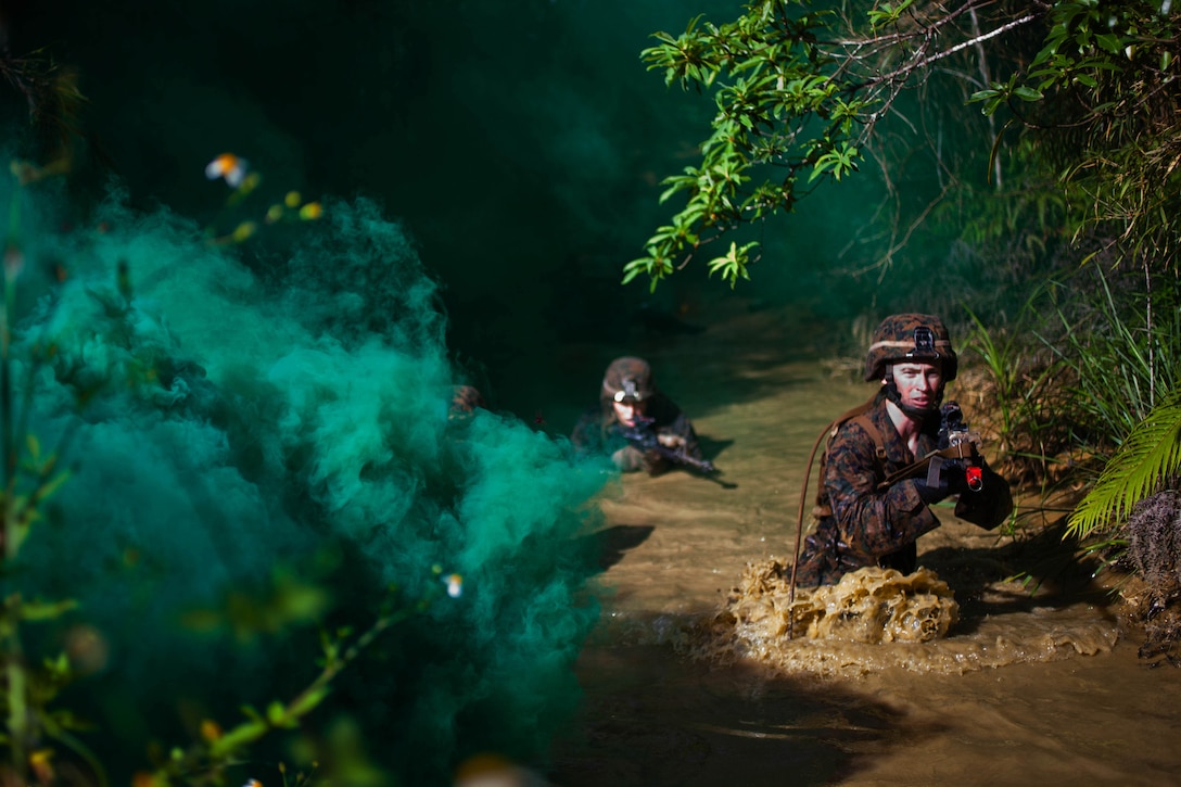 Marines with Company G., Battalion Landing Team 2nd Battalion, 4th Marines, 31st Marine Expeditionary Unit, navigate through a river under the cover of smoke during the culminating event of the Jungle Warfare Training Center’s jungle operations course here, Sept. 30. The Marines underwent a week of instruction in jungle warfare and survival skills. The culminating event tested the Marines in a jungle obstacle course spanning three miles through the Okinawan jungle. The 31st MEU is the only continuously forward-deployed MEU and is the Marine Corps’ force in readiness in the Asia-Pacific region.  