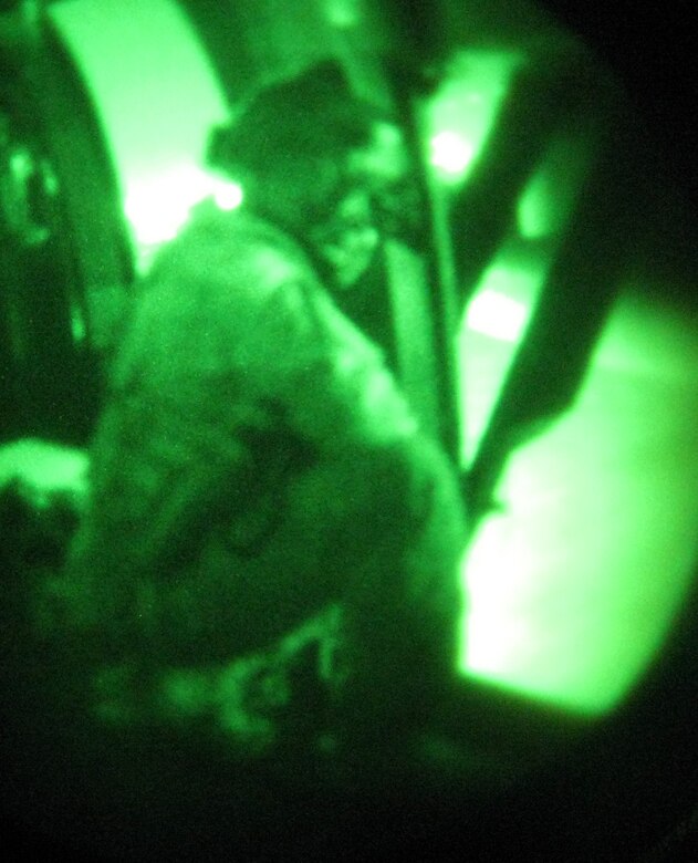A crew chief peers out the door of a UH-60 Blackhawk assigned to the 1-228th Aviation Regiment, Joint Task Force-Bravo, Soto Cano Air Base, Honduras, Oct. 2, 2013.  The crewmembers were conducting hoist training.  The aircrew members of the 1-228th regularly conduct night-flying training missions in order to maintain proficiency and currency on flying while wearing night vision goggles (NGVS).  (U.S. Air Force photo by Capt. Zach Anderson)