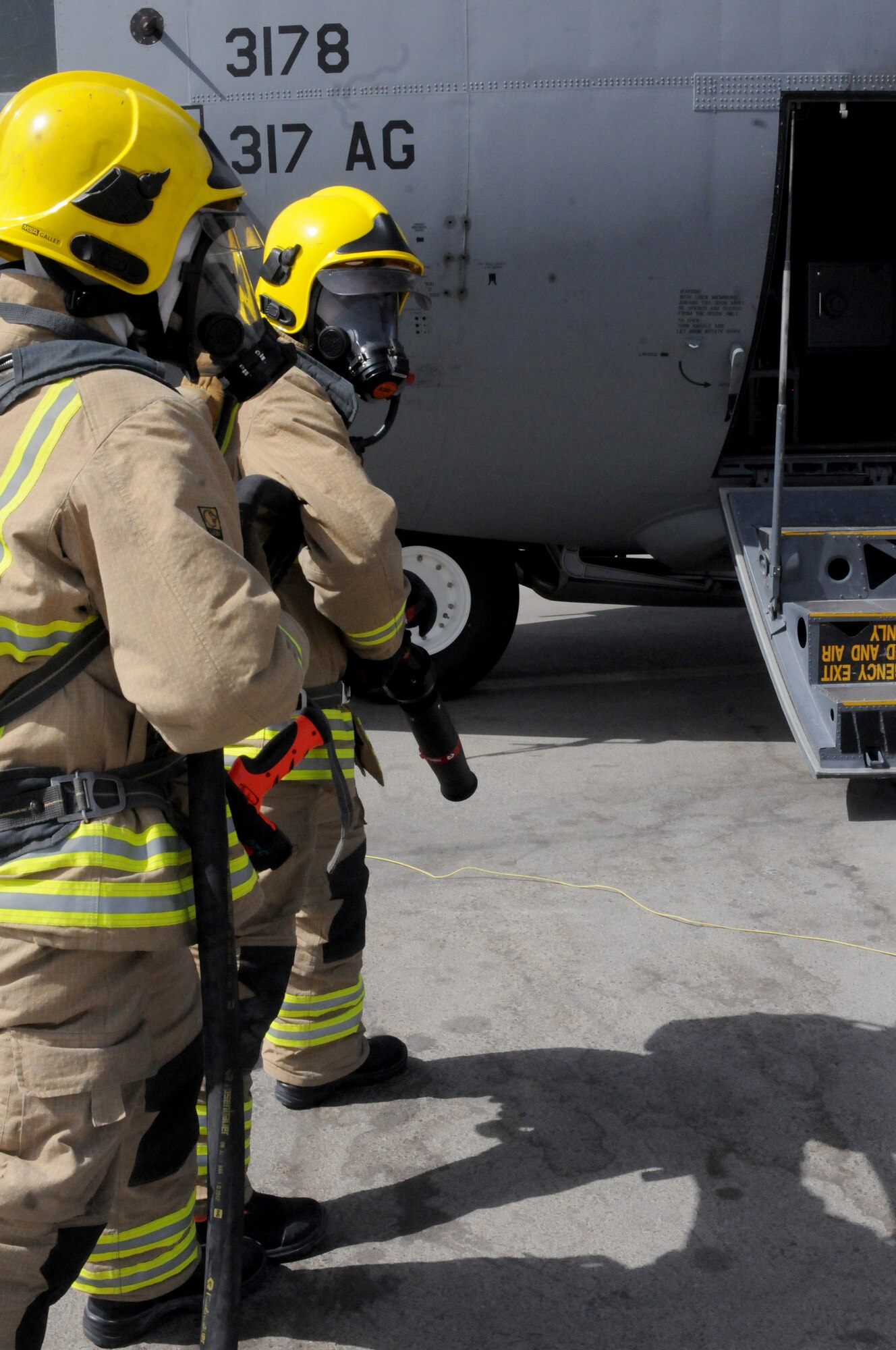 Two members of the Kandahar Fire Department emergency fire response team simulate dousing a fire onboard a C-130J Hercules during a training scenario Sept. 28, 2013, at Kandahar Airfield, Afghanistan.  Awareness and training exercises ensure emergency responders are prepared for any situation that could arise. (U.S. Air Force photo by Senior Airman Jack Sanders)