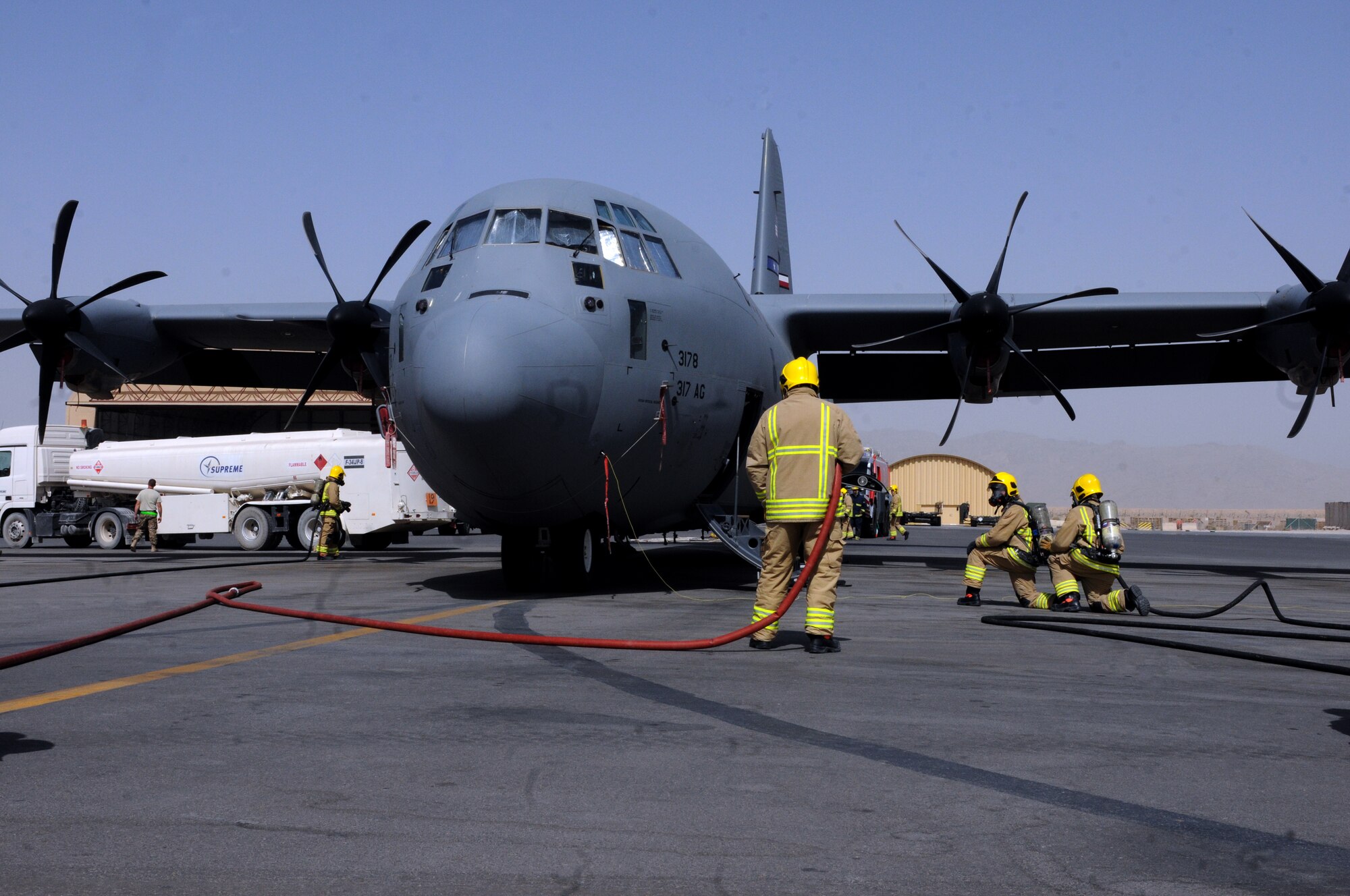 Members of the Kandahar Fire Department emergency fire response team respond to a simulated fire aboard a C-130J Hercules during fueling Sept. 28, 2013, at Kandahar Airfield, Afghanistan.  Awareness and training exercises ensure emergency responders are prepared for any situation that could arise. “We hope nothing like this will ever happen, but we want to be prepared if it ever does,” said Steve Goodfellow, KAF Fire Department fire training and support officer. (U.S. Air Force photo by Senior Airman Jack Sanders)