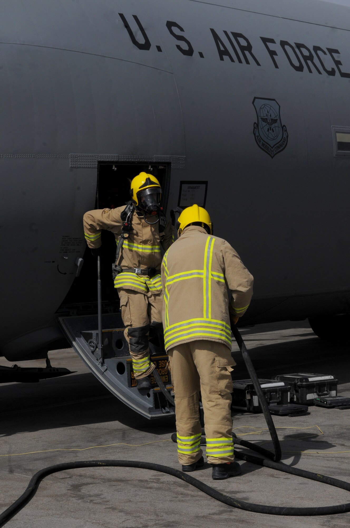 Members of the Kandahar Fire Department emergency fire response team exit a C-130J Hercules during a training exercise Sept. 28, 2013, at Kandahar Airfield, Afghanistan.  Emergency fire response team members took part in an exercise on the Airfield where they simulated responding to a fire on C-130J Hercules during refueling. (U.S. Air Force photo by Senior Airman Jack Sanders)