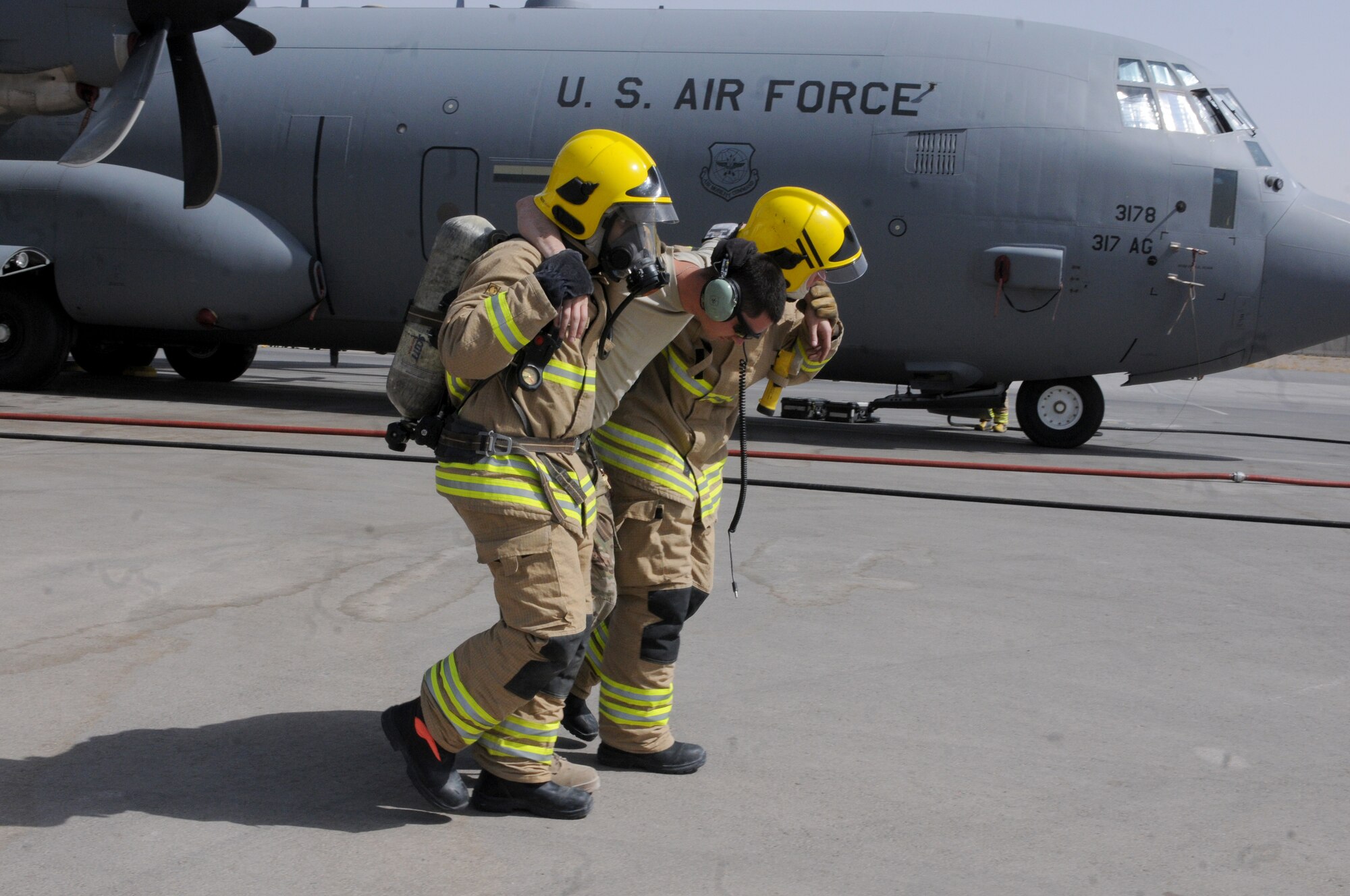 Two members of the Kandahar Fire Department emergency fire response team carry a “victim” from the scene of an “incident” during a training exercise Sept. 28, 2013, at Kandahar Airfield, Afghanistan. Awareness and training exercises ensure emergency responders are prepared for any situation that could arise. “We hope nothing like this will ever happen, but we want to be prepared if it ever does,” said Steve Goodfellow, KAF Fire Department fire training and support officer. (U.S. Air Force photo by Senior Airman Jack Sanders)