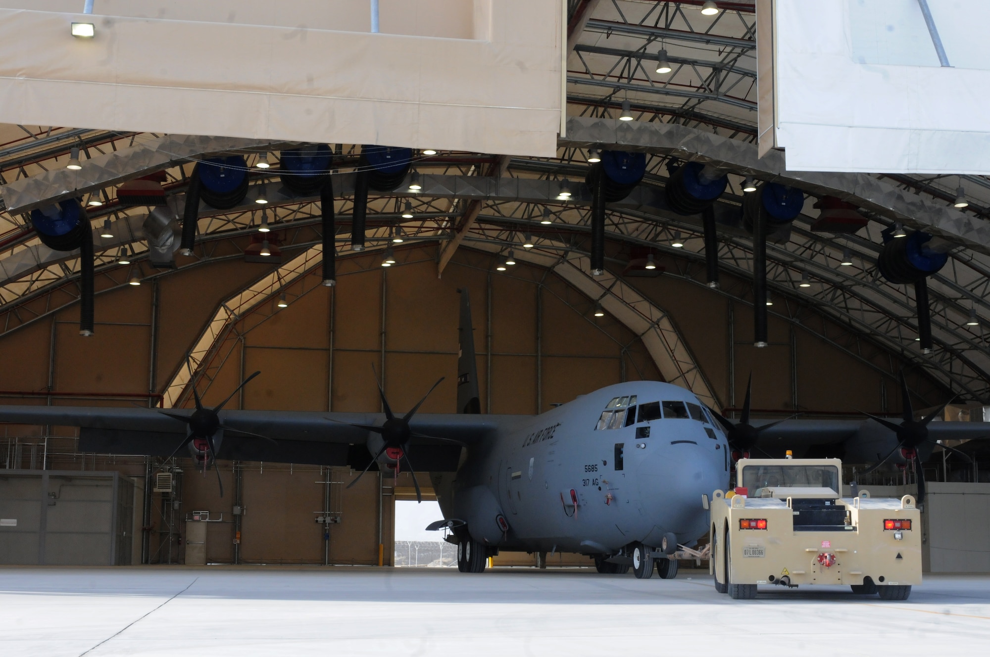 Airmen from the 451st Expeditionary Aircraft Maintenance Squadron maneuver a C-130 Hercules into a hangar Sept. 28, 2013 at Kandahar Airfield, Afghanistan. The C-130 Hercules, tail no. 85685, was the first aircraft to use the C-130 hangar that was recently completed here. (U.S. Air Force photo by Senior Airman Jack Sanders)