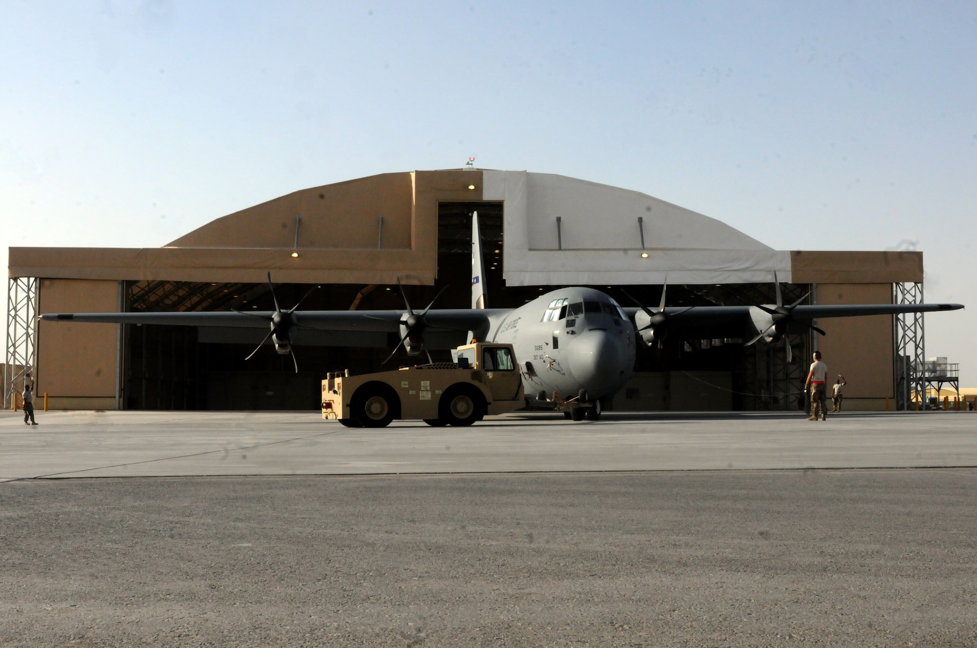 Airmen from the 451st Expeditionary Aircraft Maintenance Squadron maneuver a C-130 Hercules into a hangar Sept. 28, 2013 at Kandahar Airfield, Afghanistan. The C-130 Hercules, tail no. 85685, was the first aircraft to use the C-130 hangar that was recently completed here. (U.S. Air Force photo by Senior Airman Jack Sanders)