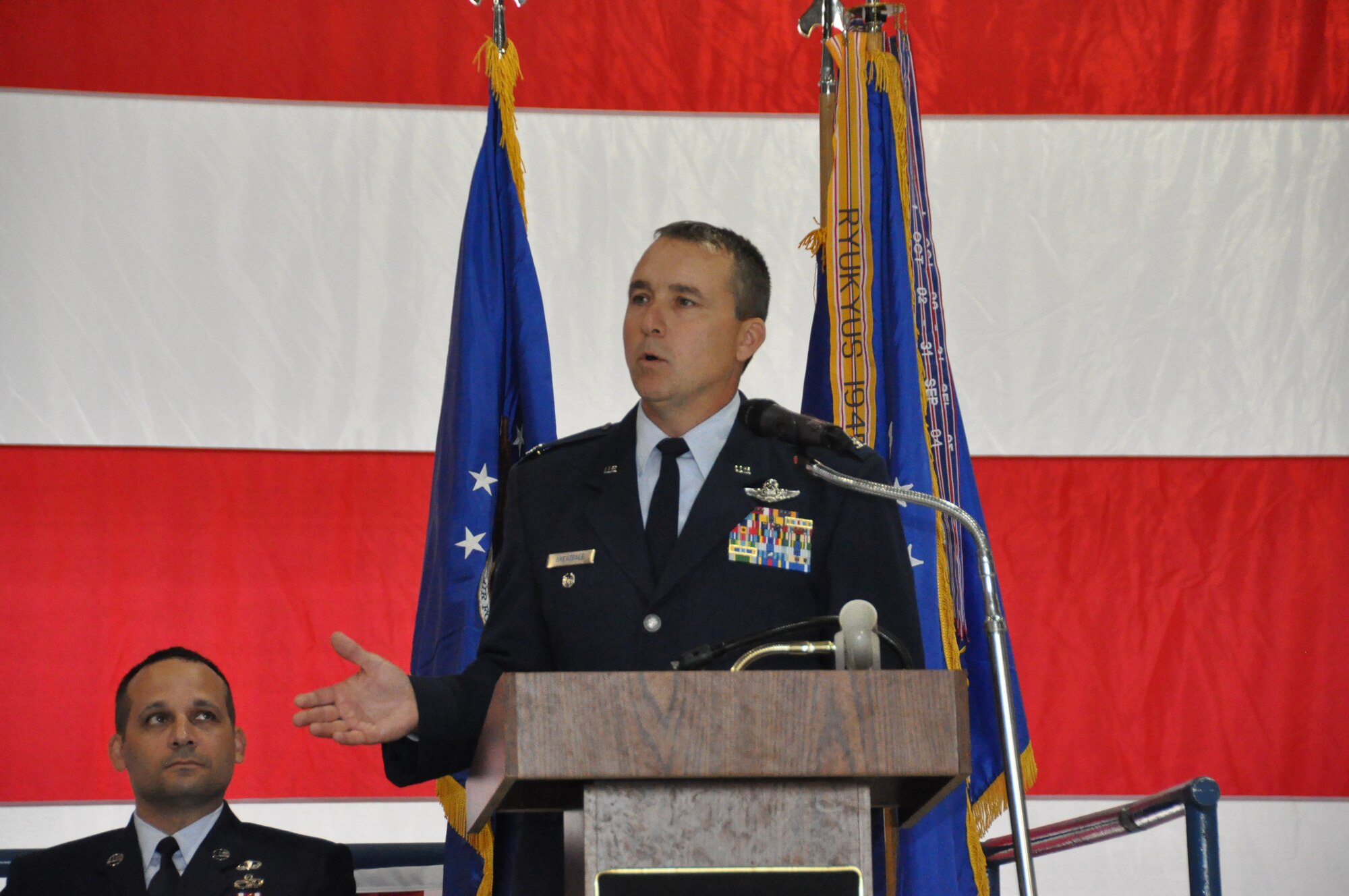 The new 301st Fighter Wing commander, Col. John Breazeale, speaks to the troops during his Change of Command ceremony Oct. 5 at Naval Air Station Fort Worth Joint Reserve Base, Texas, while CMSgt Brian Pinsky, 301st FW's Command Chief Master Sergeant, looks on. Maj. Gen. William Binger, 10th Air Force commander, presided over the ceremony. (U.S. Air Force photo/MSgt Julie Briden-Garcia)