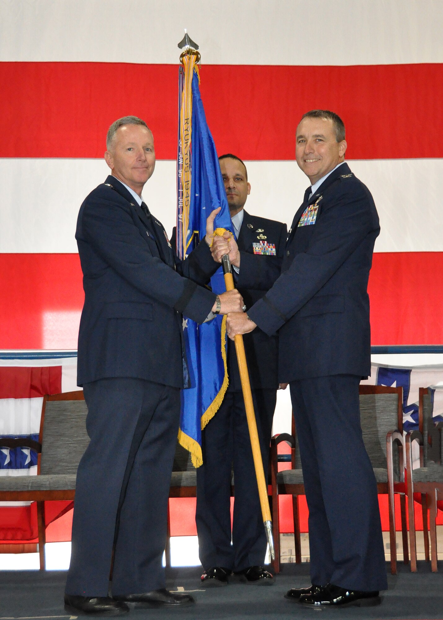 Maj. Gen. William Binger, 10th Air Force commander, hands the reins over to the new 301st Fighter Wing commander, Col. John Breazeale, during the Change of Command ceremony Oct. 5 at Naval Air Station Fort Worth Joint Reserve Base, Texas. CMSgt Brian Pinsky, 301st FW's Command Chief Master Sergeant, waits for the wing's guideon. (U.S. Air Force photo/MSgt Julie Briden-Garcia)