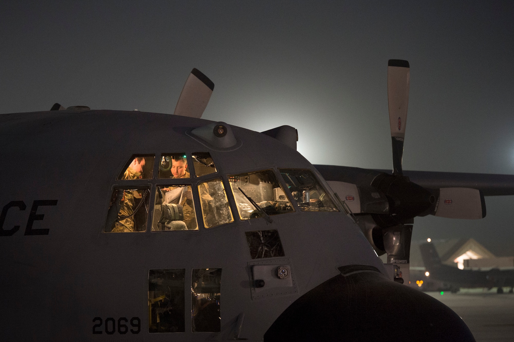 Maj. Devin Cummings, 774th Expeditionary Airlift Squadron pilot, talks through the day's flight with crew members aboard a C-130 Hercules cargo plane at Bagram Air Field, Afghanistan, Sept. 28, 2013. This mission marked a retrograde milestone as the 774th EAS transported the last cargo from Forward Operating Base Sharana, Paktika province, Afghanistan, before the base is transferred to the Afghan Ministry of Defense. Cummings, a Manitowoc, Wis. native, is deployed from Peterson Air Force Base, Colo. (USAF Photo/Master Sgt. Ben Bloker)