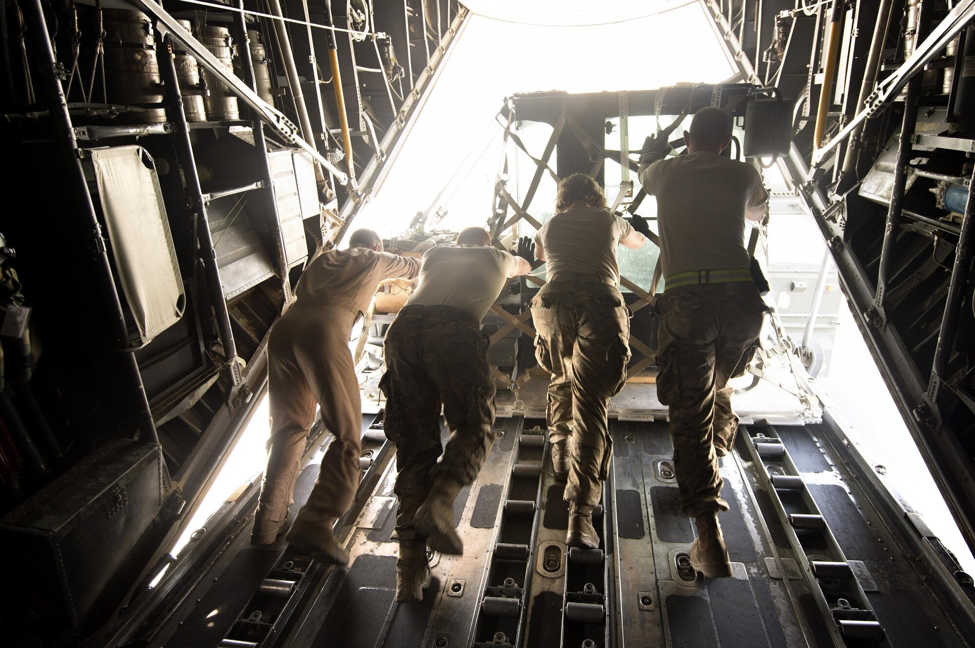 Senior Airman Zac Sidders, 774th Expeditionary Airlift Squadron loadmaster, assists aerial porters from the 455th Expeditionary Aerial Port Squadron pushing cargo off a C-130 Hercules at Bagram Air Field, Afghanistan, Sept. 28, 2013. This mission marked a retrograde milestone as the 774th EAS transported the last cargo from Forward Operating Base Sharana, Paktika province, Afghanistan, before the base is transferred to the Afghan Ministry of Defense. Sidders, a Peoria, Ill., native, is deployed from the Wyoming Air National Guard. 