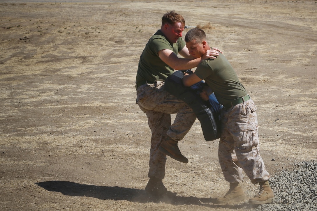 With a face covered in pepper spray, Lance Cpl. Nicholas Vanhoorebeke, rifleman, Delta Company, 1st Battalion, 1st Marine Regiment, delivers a knee strike to a punching bag simulating an aggressor during a nonlethal weapons training course here, Oct. 1, 2013. Marines with Delta Company are preparing for a deployment to the Middle East where they’ll provide embassy security. Vanhoorebeke is a native of Mount Vernon, Ill.