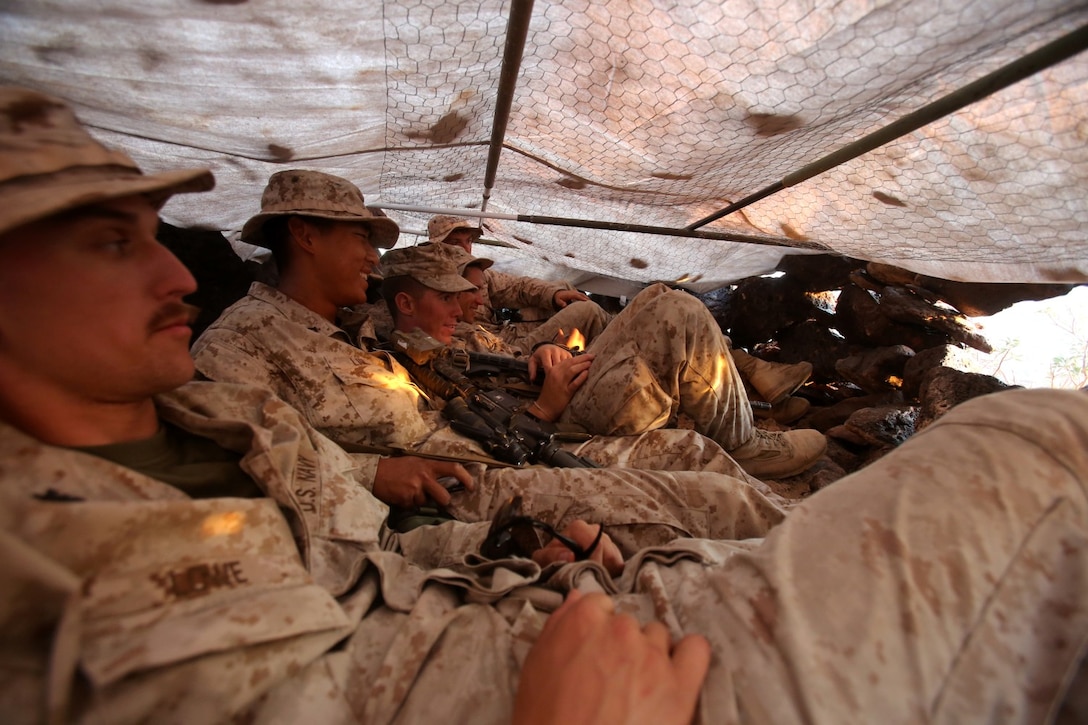 MARINE CORPS AIR STATION YUMA, Ariz. – Marines with Scout Sniper Platoon, 1st Battalion, 7th Marine Regiment, lay inside a hide site after constructing it to test its capacity during Weapons Tactics Instructors course here, Sept. 25, 2013. Hide sites are used as positions for Marines to observe and, if needed, fire from. Their structure provides 360 degree concealment, maximum fields of observation and protection from weather.