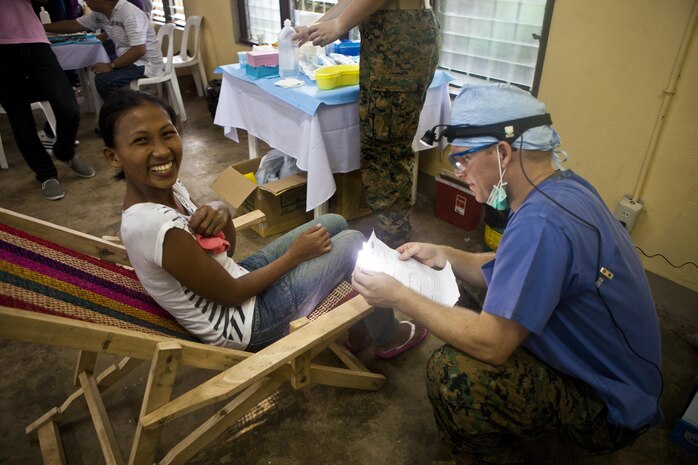 U.S. Navy Lt. Seth Perrins, dentist, 3d Medical Battalion, 3d Marine Expeditionary Brigade, III Marine Expeditionary Force, provides dental care to a Legazpi citizen during a cooperative health engagement at Bigaa Elementary School, Legazpi City, Albay, Republic of the Philippines, Sept. 26, 2013 as part of Amphibious Landing Exercise 2014 (PHIBLEX 14).  Members of the Armed Forces of the Philippines, and U.S. Marines and sailors from 3d MEB are conducting humanitarian and civic assistance projects, which include engineering projects and cooperative health engagements, in Legazpi City as part of PHIBLEX 14.  Humanitarian and civic assistance projects enable Philippine and U.S. military members to learn about each other's culture, train together, and improve interoperability while providing services to areas with identified need.  (U.S. Marine Corps photo by Lance Cpl. Katelyn Hunter/Released)