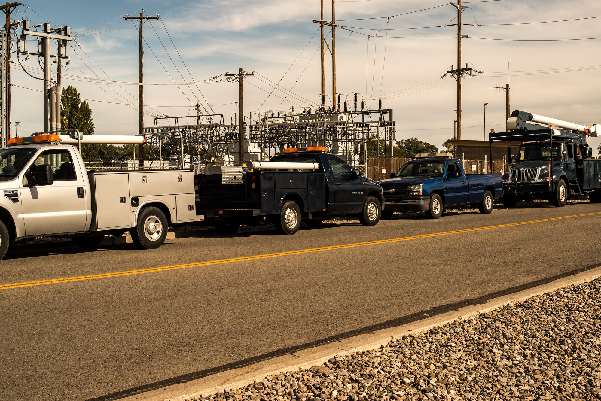 Trucks line the road as technicians from the 366th Civil Engineer Squadron and Idaho Power Company switch circuits and restore power to Mountain Home Air Force Base, Idaho, Oct. 7, 2013. The base was without power for a few hours after the main circuit bringing power to the base malfunctioned. (U.S. Air Force photo by Master Sgt. Kevin Wallace/RELEASED)