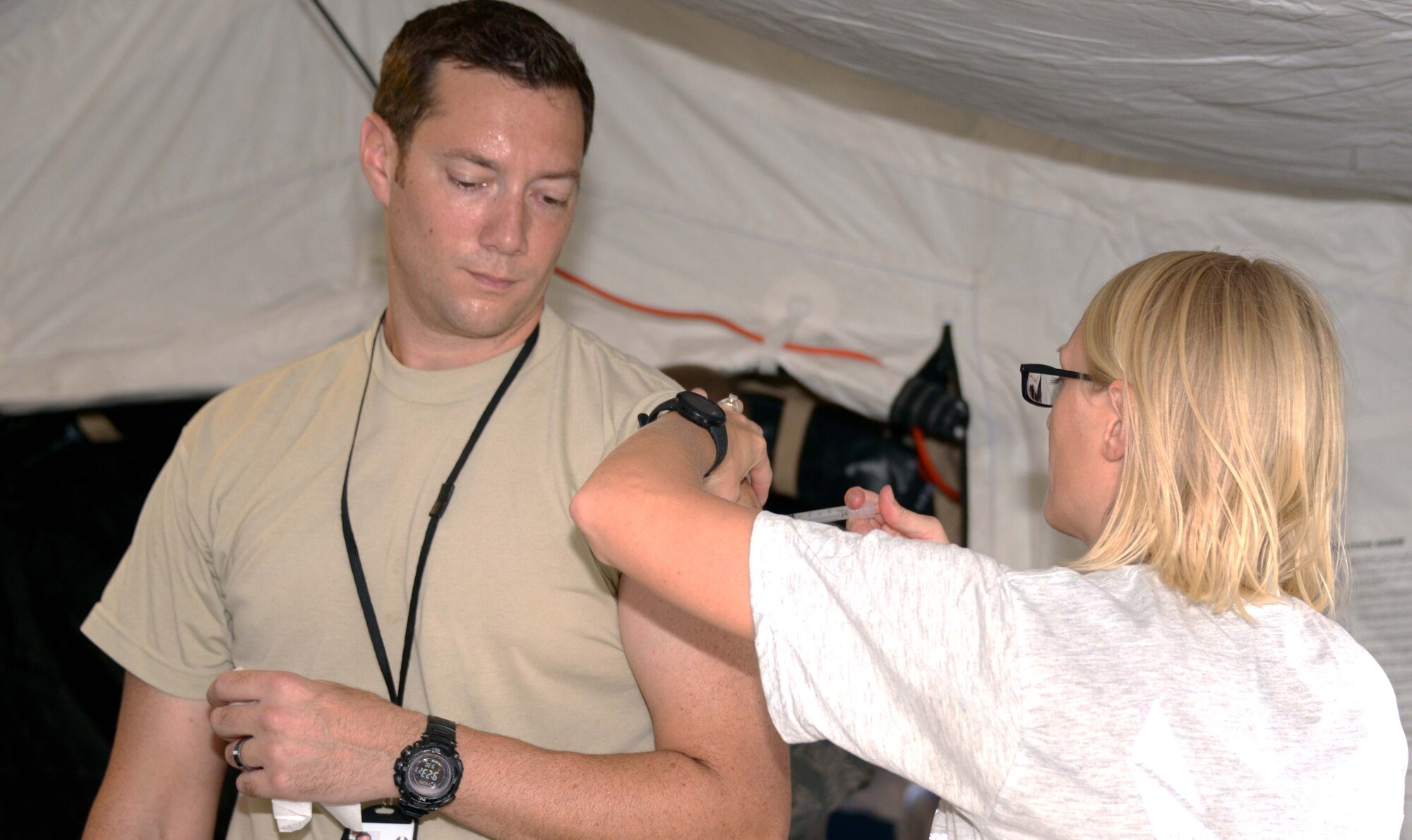 Staff Sgt. Alicia Chavez, 353rd Special Operations Support Squadron, gives Maj. Jared Floyd, 1st Special Operations Squadron, an immunization shot Sept. 30, 2013 on Kadena AB, Japan.  The 353rd SOSS medical flight functioned out of their Air Transportable Treatment Unit while delivering medical readiness items such as four blood draws and nearly 250 immunizations to include the annual flu mist. (Air Force photo by Tech. Sgt. Kristine Dreyer) )