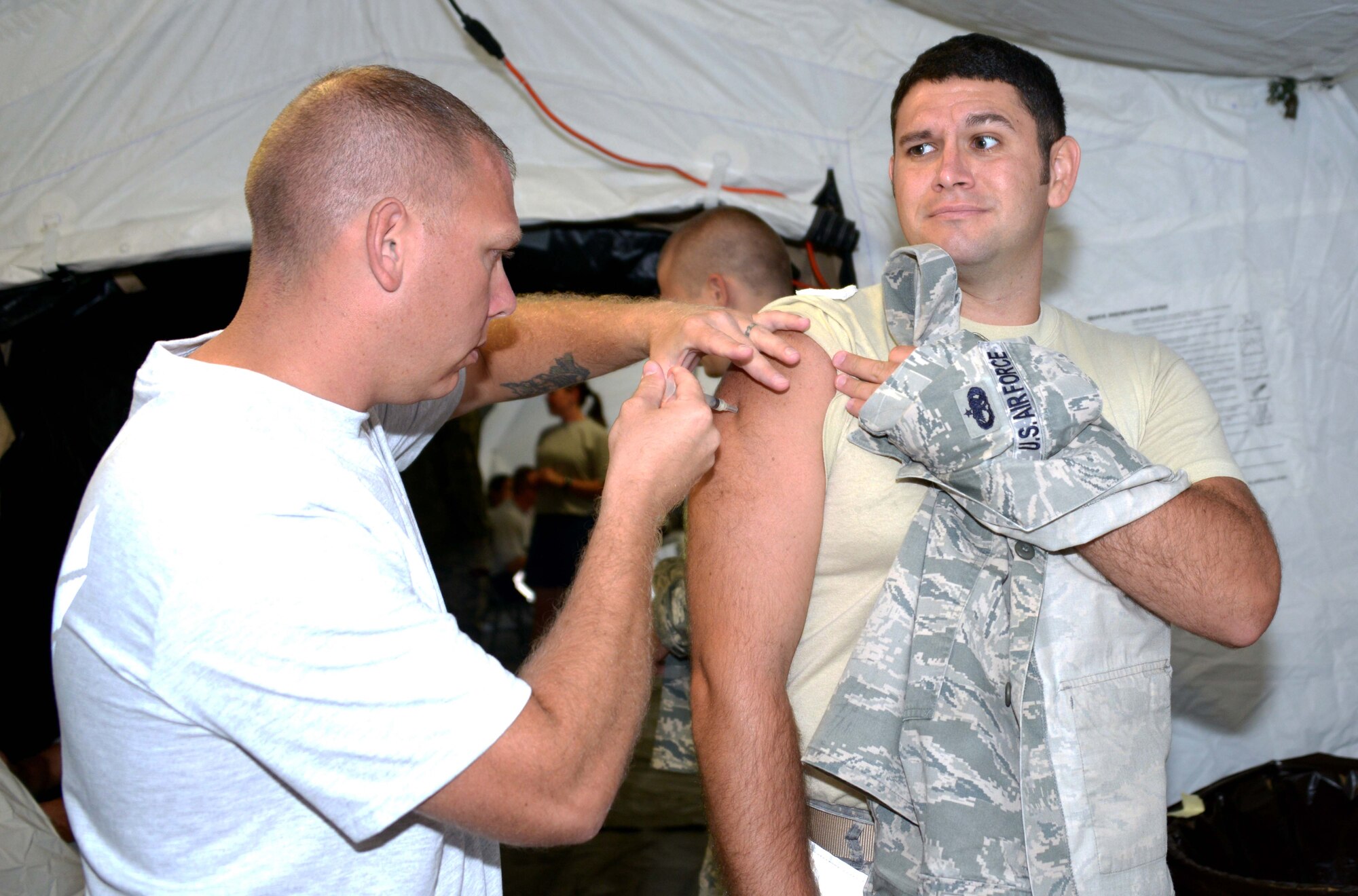 Tech. Sgt. Ronald Viramontes, 353rd Special Operations Support Squadron, gives Staff Sgt. Christopher Maquilon, 353rd Special Operations Group, an immunization shot Sept. 30, 2013 on Kadena AB, Japan.  The 353rd SOSS medical flight functioned out of their Air Transportable Treatment Unit while delivering medical readiness items such as four blood draws and nearly 250 immunizations to include the annual flu mist.  (Air Force photo by Tech. Sgt. Kristine Dreyer)