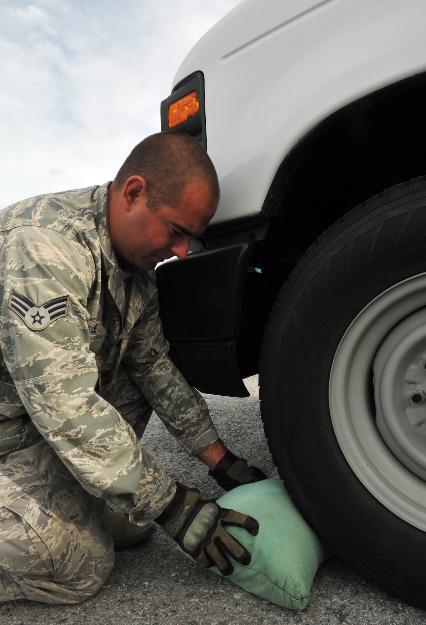 U.S. Air Force Senior Airman Keith Lee, 18th Logistics Readiness Squadron vehicle operator, sandbags a vehicle during Typhoon Fitow preparation at Kadena Air Base, Japan, Oct. 4, 2013. The typhoon hit the island the evening of Oct. 5. The winds reached 47 to 72 knots. (U.S. Air Force photo by Naoto Anazawa)