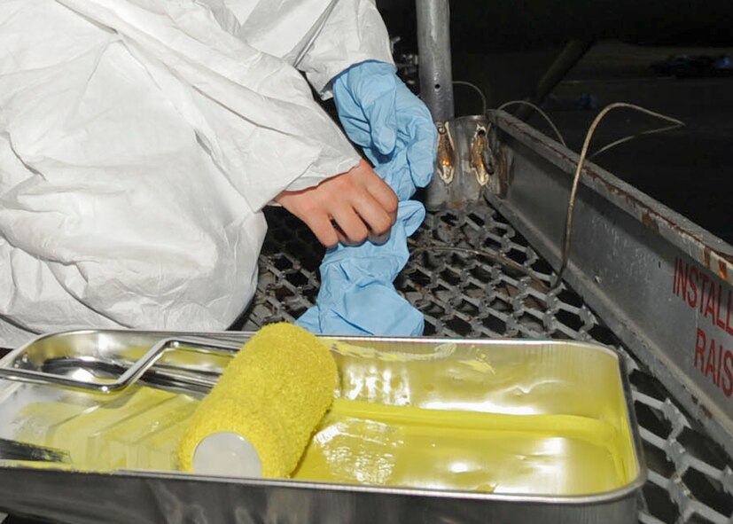 Airman 1st Class Shelby Pearson, 2nd Maintenance Squadron aircraft structural maintenance journeyman, puts on safety gloves before priming a B-52H Stratofortress on Barksdale Air Force Base, La., Oct. 7, 2013. The primer contains toxins that can be absorbed in the skin. (U.S. Air Force photo/ Senior Airman Kristin High)
