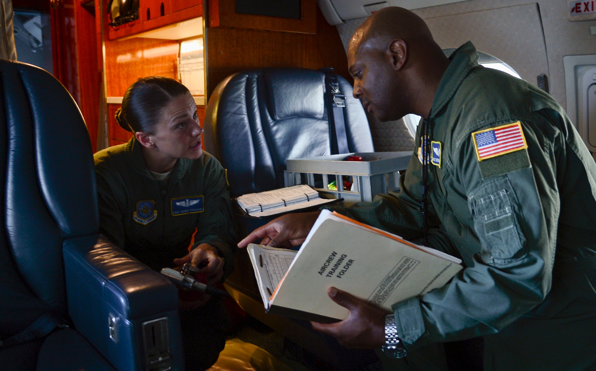 Tech. Sgt. Renee Strayer, 310th Airlift Squadron flight attendant, and Master Sgt. Sedrick Roberson, 310th AS flight chief flight attendant, go over a safety checklist before their next mission at MacDill Air Base, Fla., Oct. 1, 2013. Safety is a flight attendants number one priority during their mission. (U.S. Air Force photo by Airman 1st Class Tori Schultz/Released)