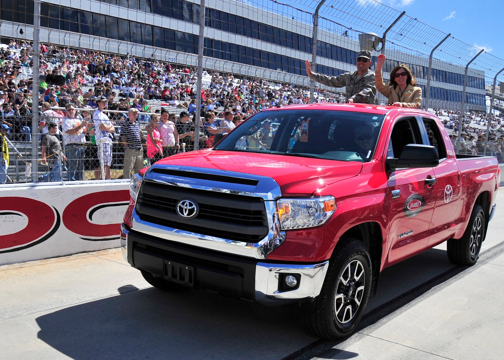 Col. Raymond A. Kozak, 512th Airlift Wing commander, and his wife Maureen, wave to the crowd before the start of the AAA 400 Sept. 29, 2013, at Dover International Speedway in Dover, Del. Representing the Air Force Reserve, Kozak was part of the big Team Dover presence at the track during race weekend. (U.S. Air Force photo/Tech. Sgt. Chuck Walker)