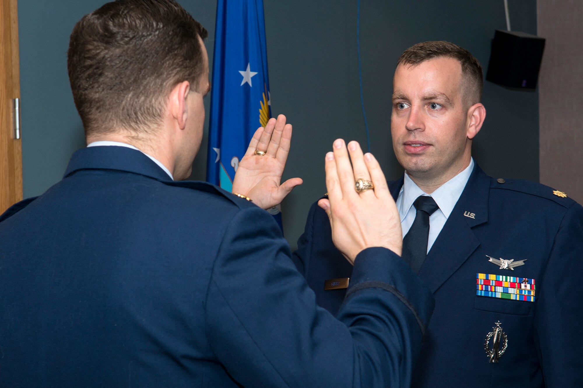 U.S. Air Force Maj. Keith Gibbs (right) recites the oath given by his brother, Maj. Kevin Gibbs, during a Pinning On ceremony, Oct. 5, 2013, Barksdale Air Force Base, La. Keith Gibbs is assigned to the 307th Bomb Wing Command Post and was recently promoted to the rank of Major. (U.S. Air Force photo by Master Sgt. Greg Steele/Released)